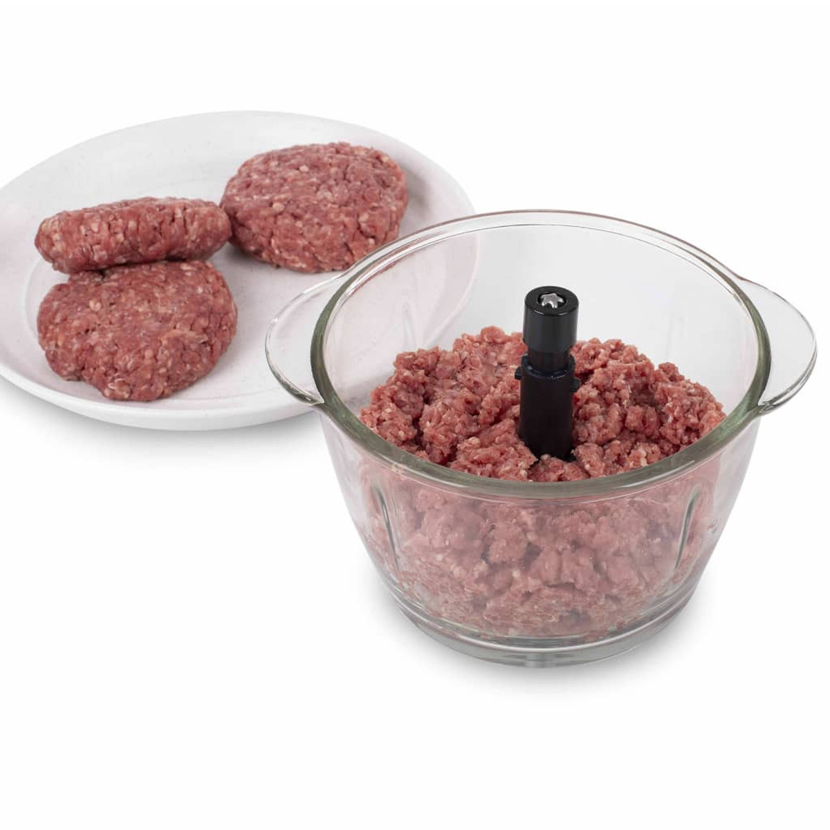 Carne macinata in una ciotola di vetro, con alcune polpette crude su un piatto bianco.