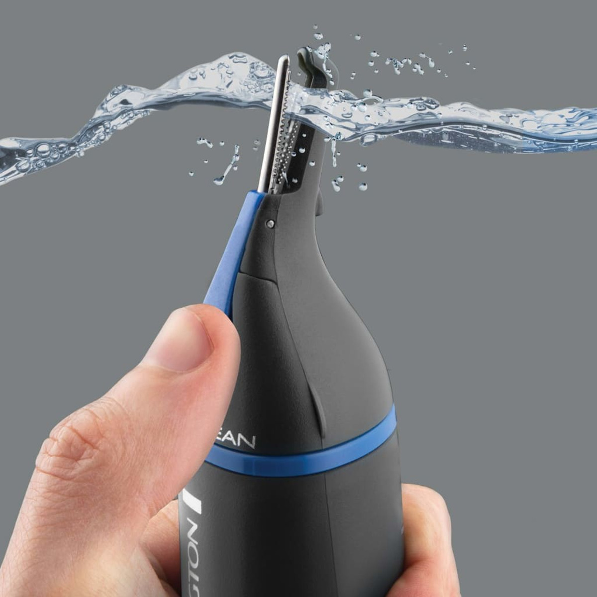 Una mano sostiene un recortador de vello nasal negro y azul bajo el agua.