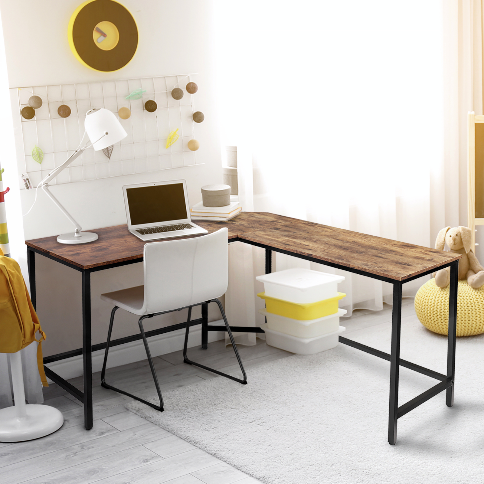 Ein Holzschreibtisch in einem Raum mit Laptop, Lampe, Stuhl und Aufbewahrungsboxen. Fenster im Hintergrund.