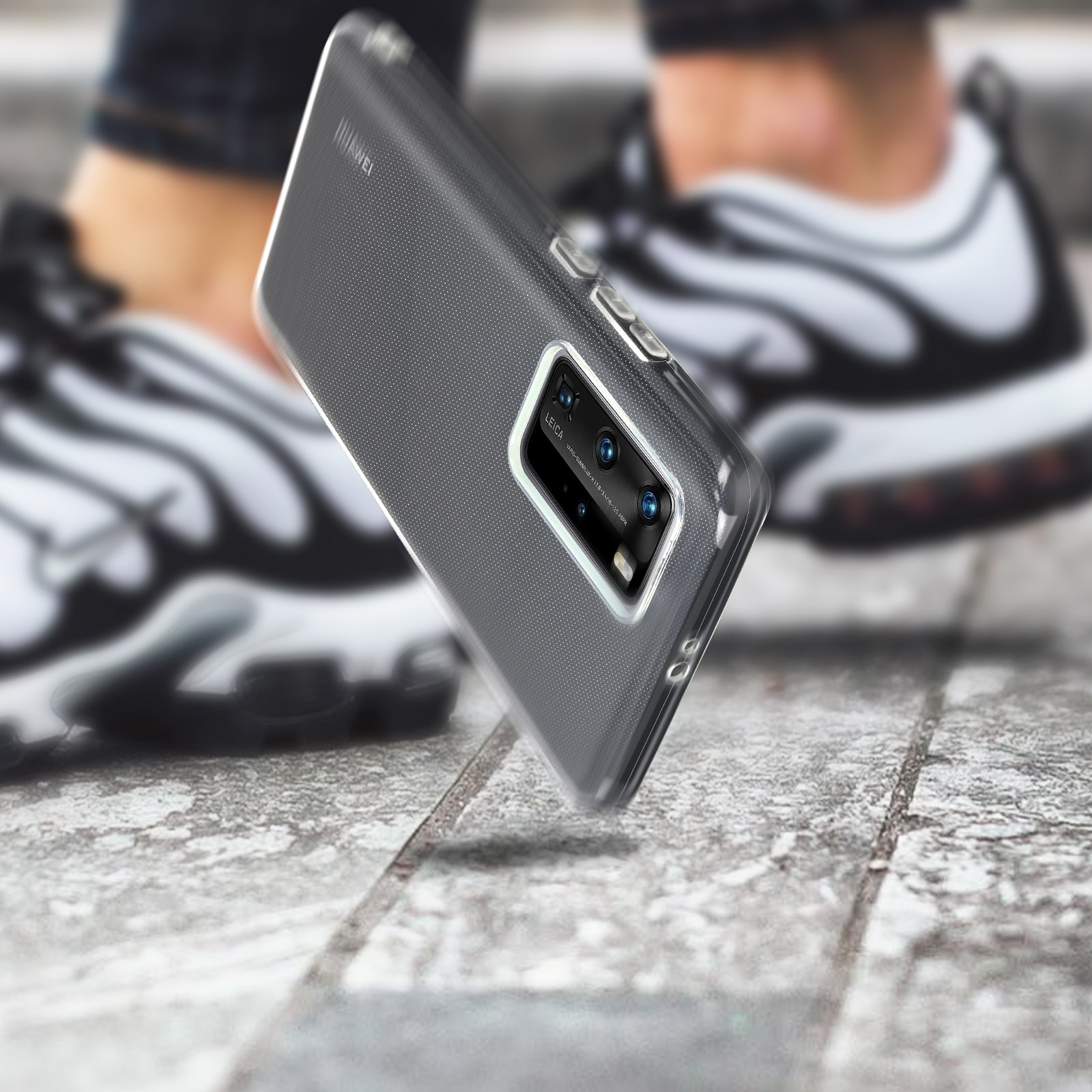 Custodia trasparente per telefono, con telefono dentro, e scarpe da ginnastica su pietra.