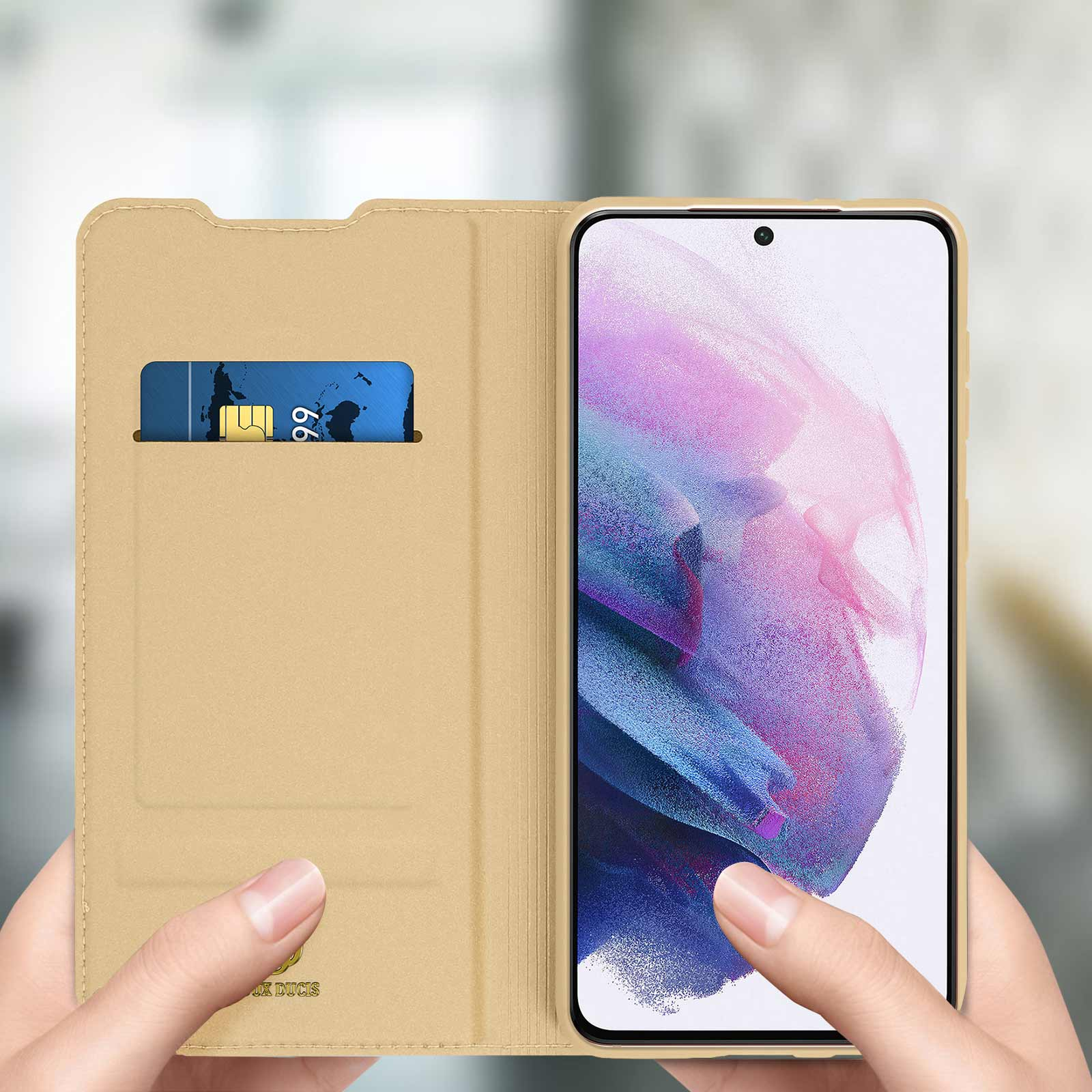 Goldene Handyhülle mit Kreditkartenfach. Eine Hand hält das Telefon.