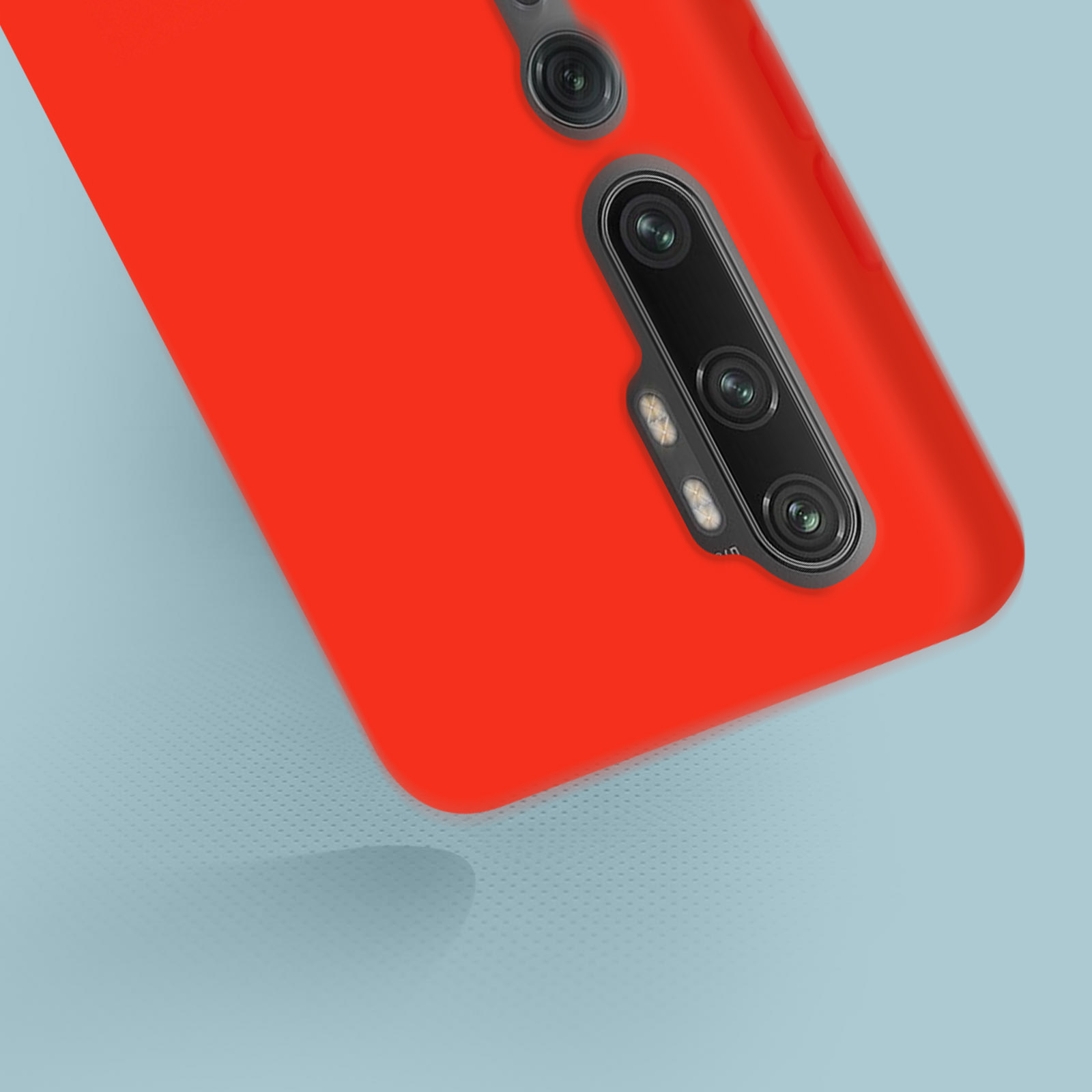 Primo piano di una custodia rossa con lenti della fotocamera nere. La custodia è angolata con uno sfondo azzurro.