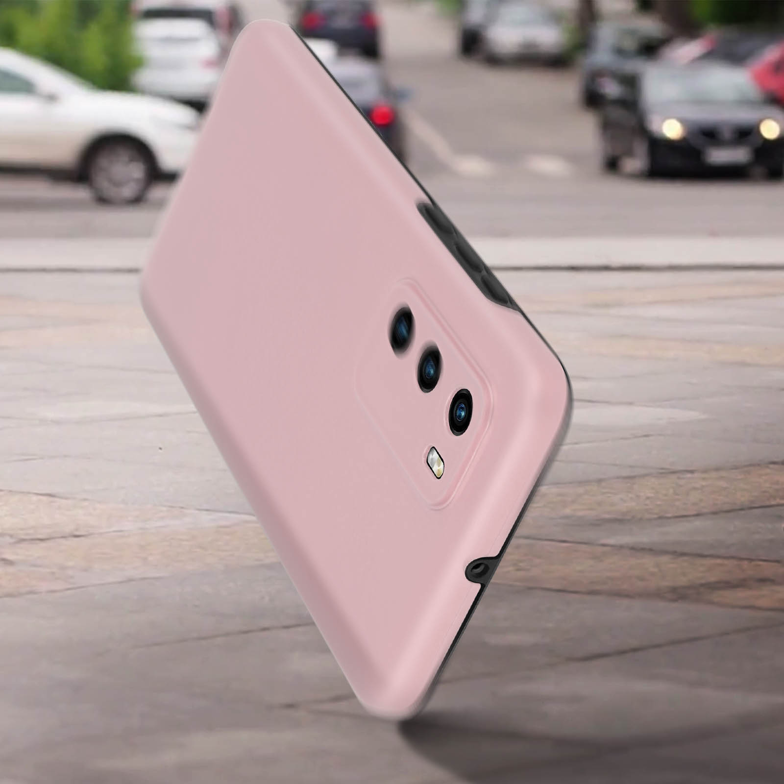 Een lichtroze telefoonhoesje op een telefoon, met een vage achtergrond van een straat met auto's.