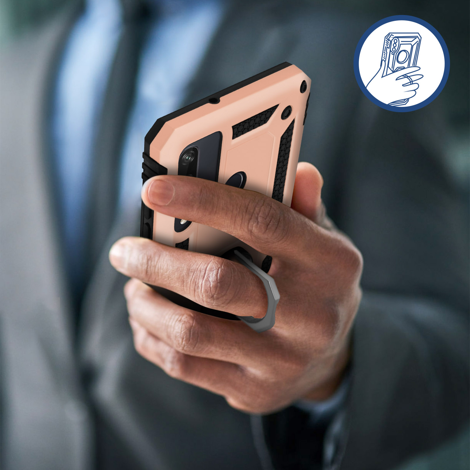 Eine Hand hält eine Handyhülle mit einem Fingerring auf der Rückseite, vor unscharfem Hintergrund.
