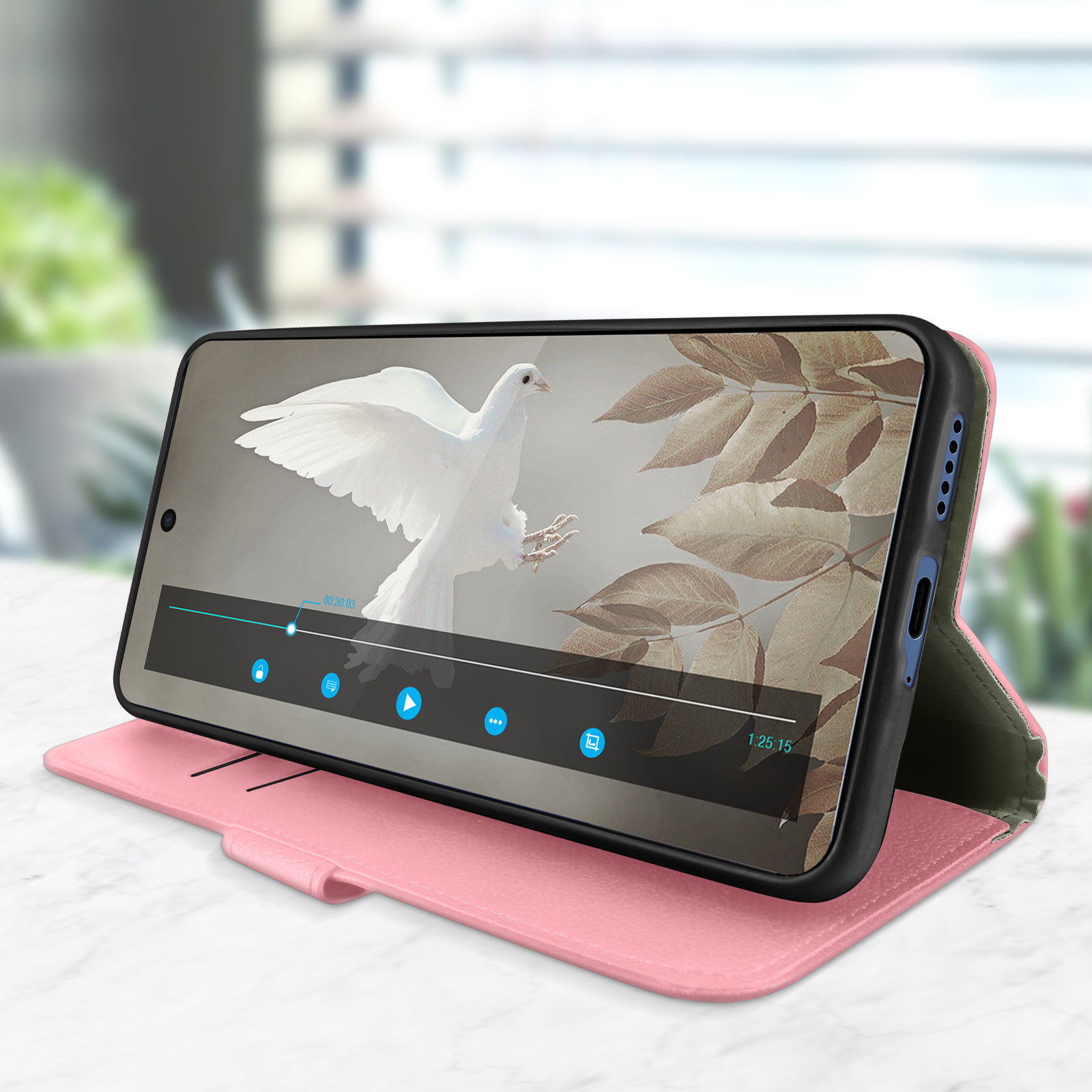 Un telefono in una custodia a portafoglio rosa, con un video in riproduzione sullo schermo.