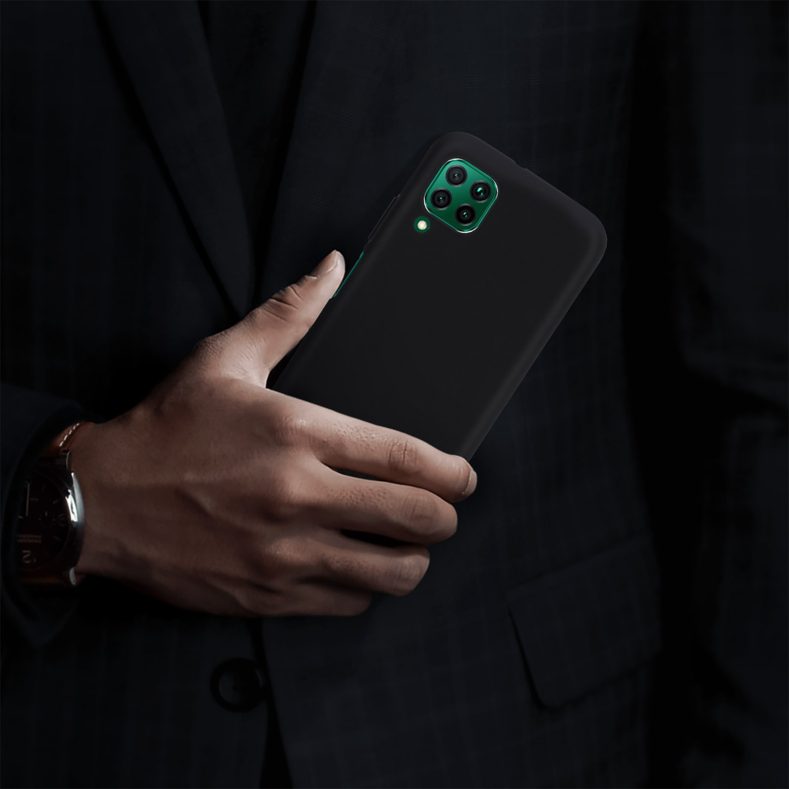 Eine Person im Anzug hält ein schwarzes Telefon. Das Telefon hat grüne Kameralinsen. Der Hintergrund ist dunkel.