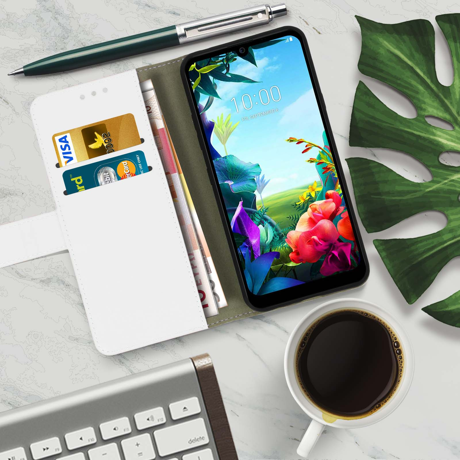 Un smartphone, una cartera, un bolígrafo y una taza de café sobre una superficie de mármol.