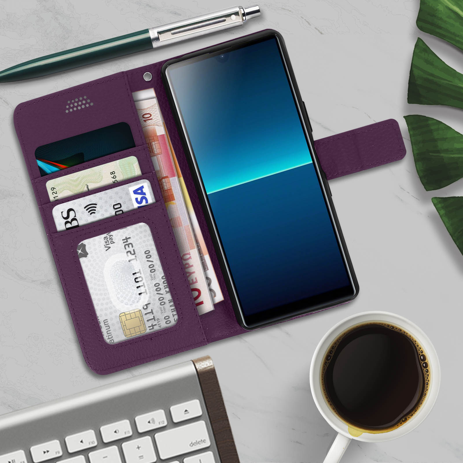Un telefono in una custodia viola con carte, soldi e una penna e caffè su un tavolo di marmo.