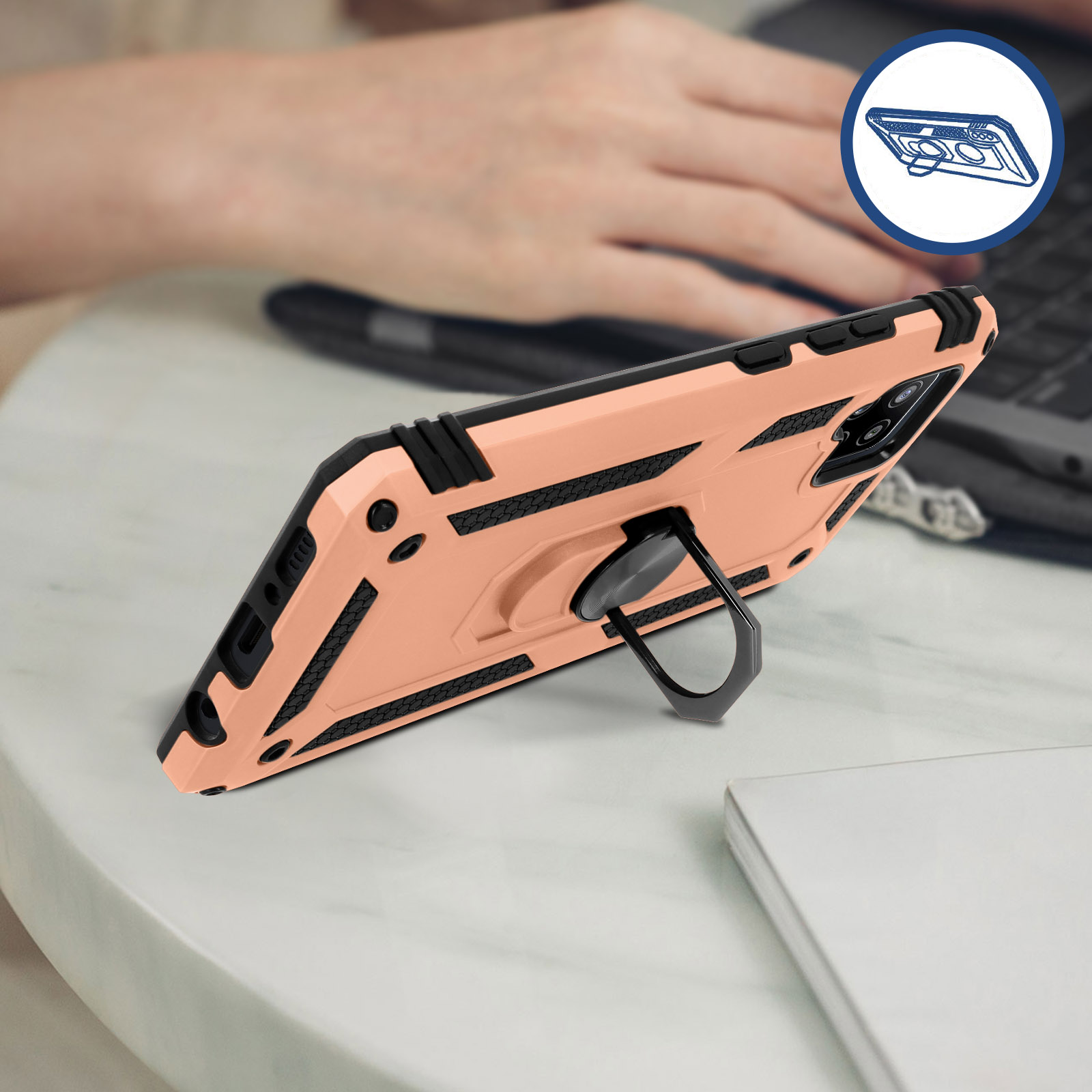 Handyhülle mit Ringhalter auf einem Tisch, mit Hand und Laptop im Hintergrund.