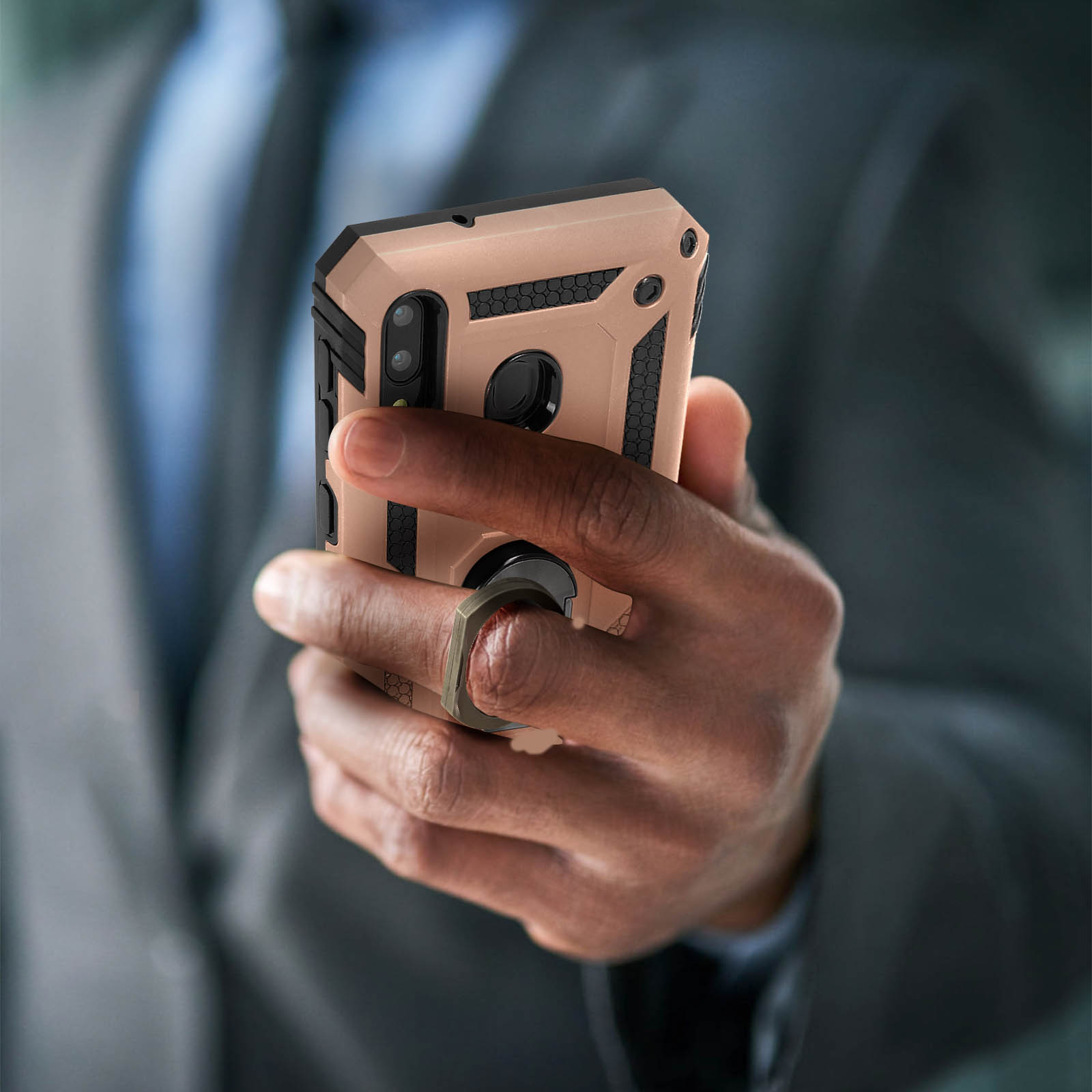 Eine Person, die ein Telefon in einer Schutzhülle hält. Die Hülle ist beige und schwarz. Verschwommener Hintergrund.