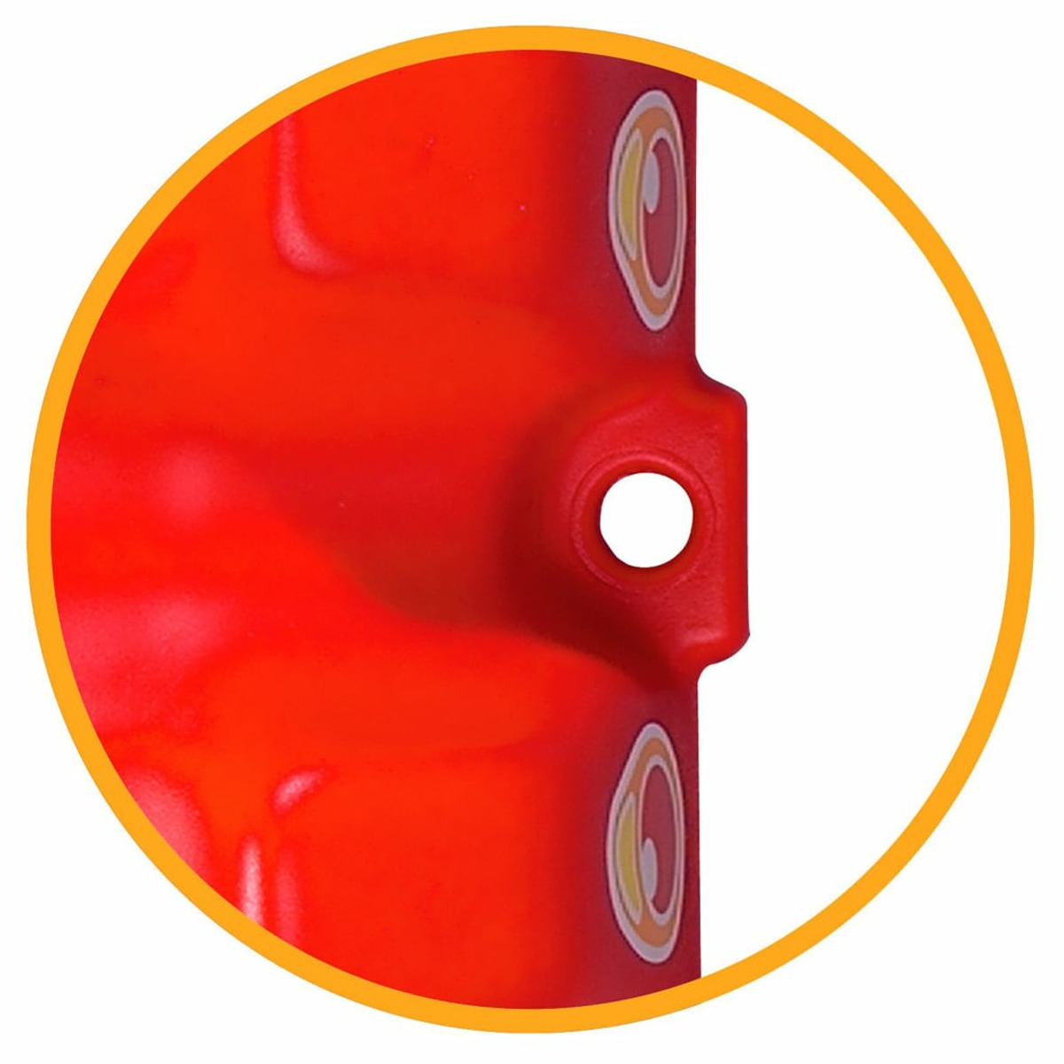 Primo piano di un oggetto di plastica rossa con ritagli circolari all'interno di un cerchio giallo.