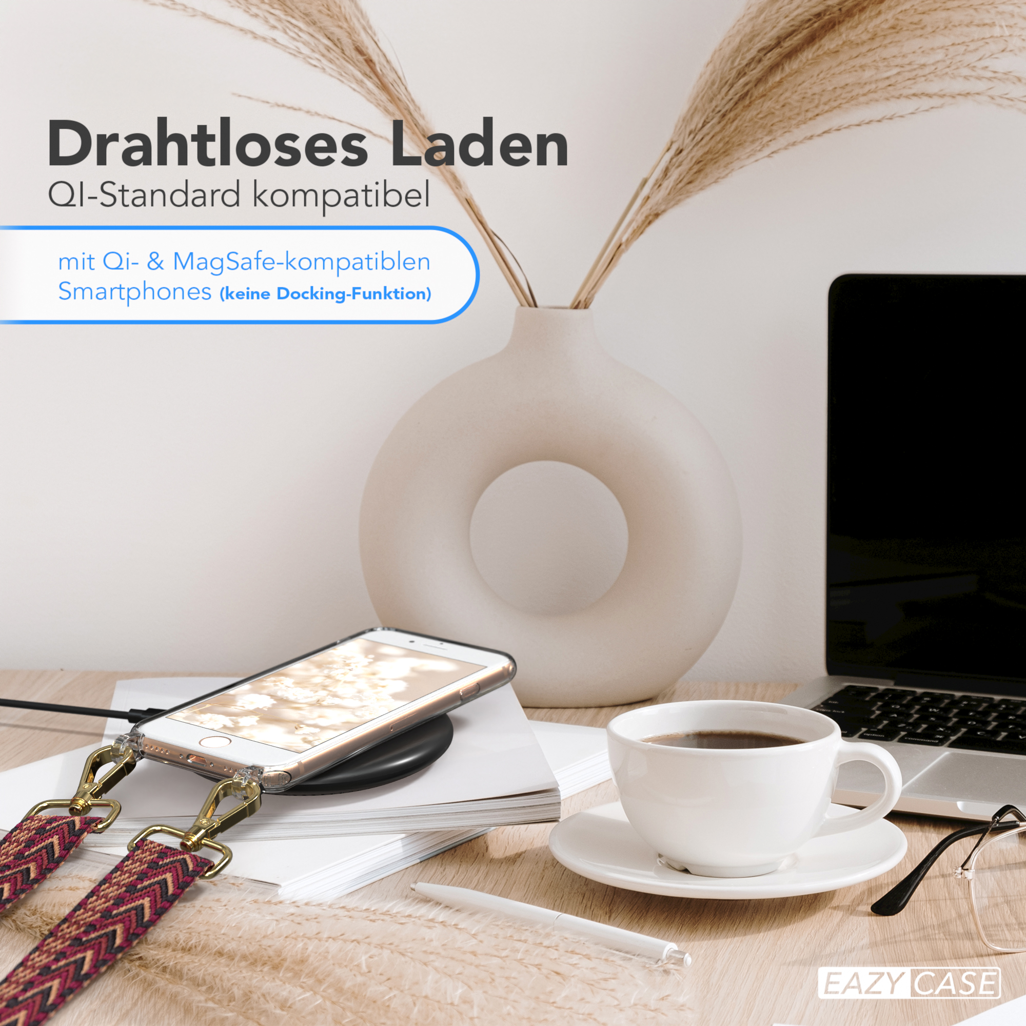 Telefon auf kabellosem Ladegerät. Kaffeetasse, Stift und Blumen auf einem Schreibtisch.
