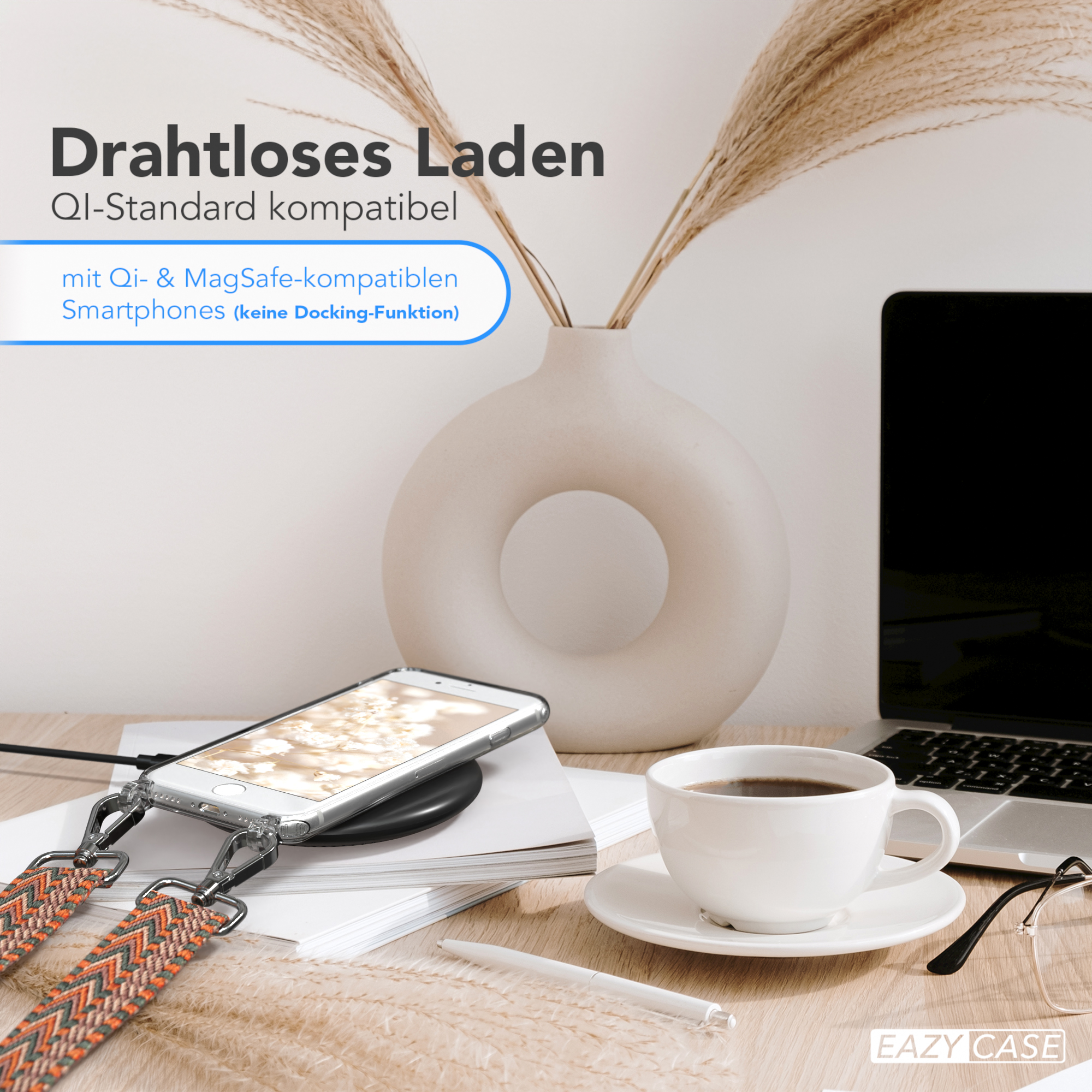 Ein Telefon mit Lanyard auf einem kabellosen Ladegerät, neben einer Kaffeetasse und einer Vase.