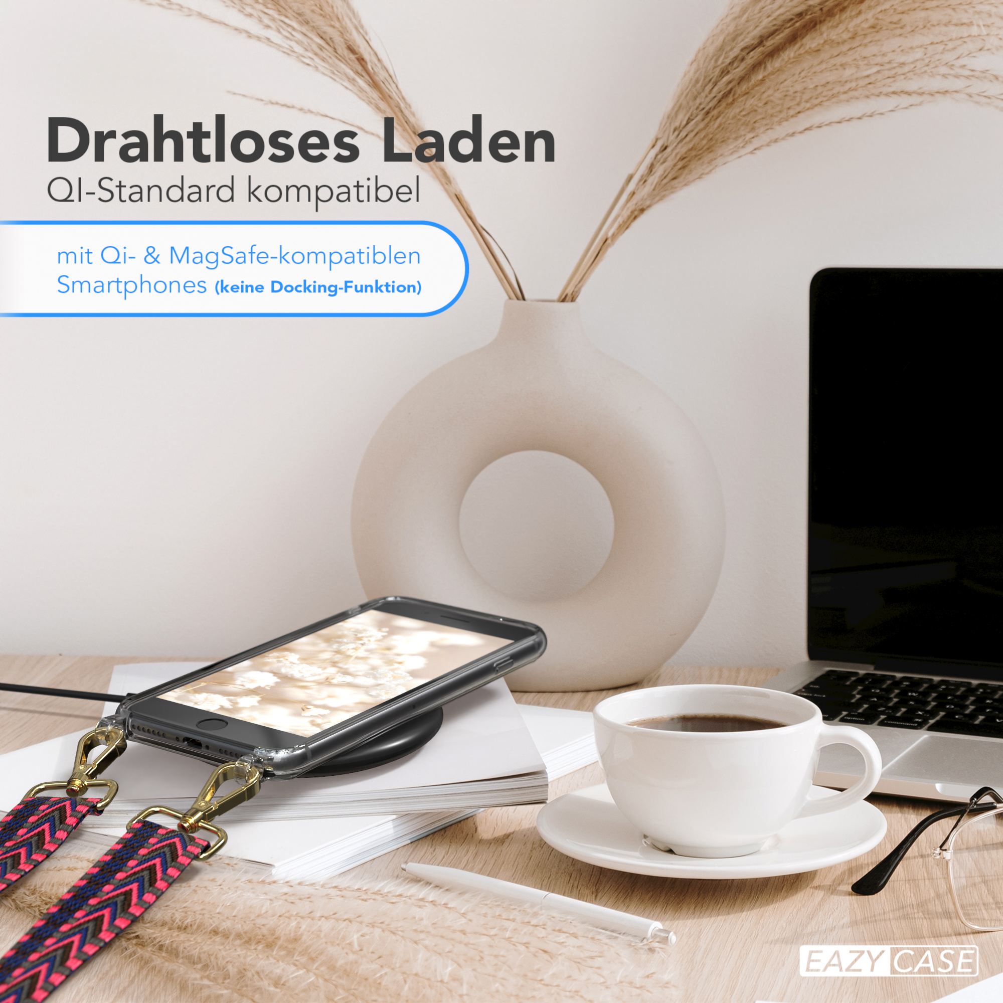Ein Telefon wird drahtlos mit dekorativem Riemen aufgeladen, daneben eine Tasse und Deko.
