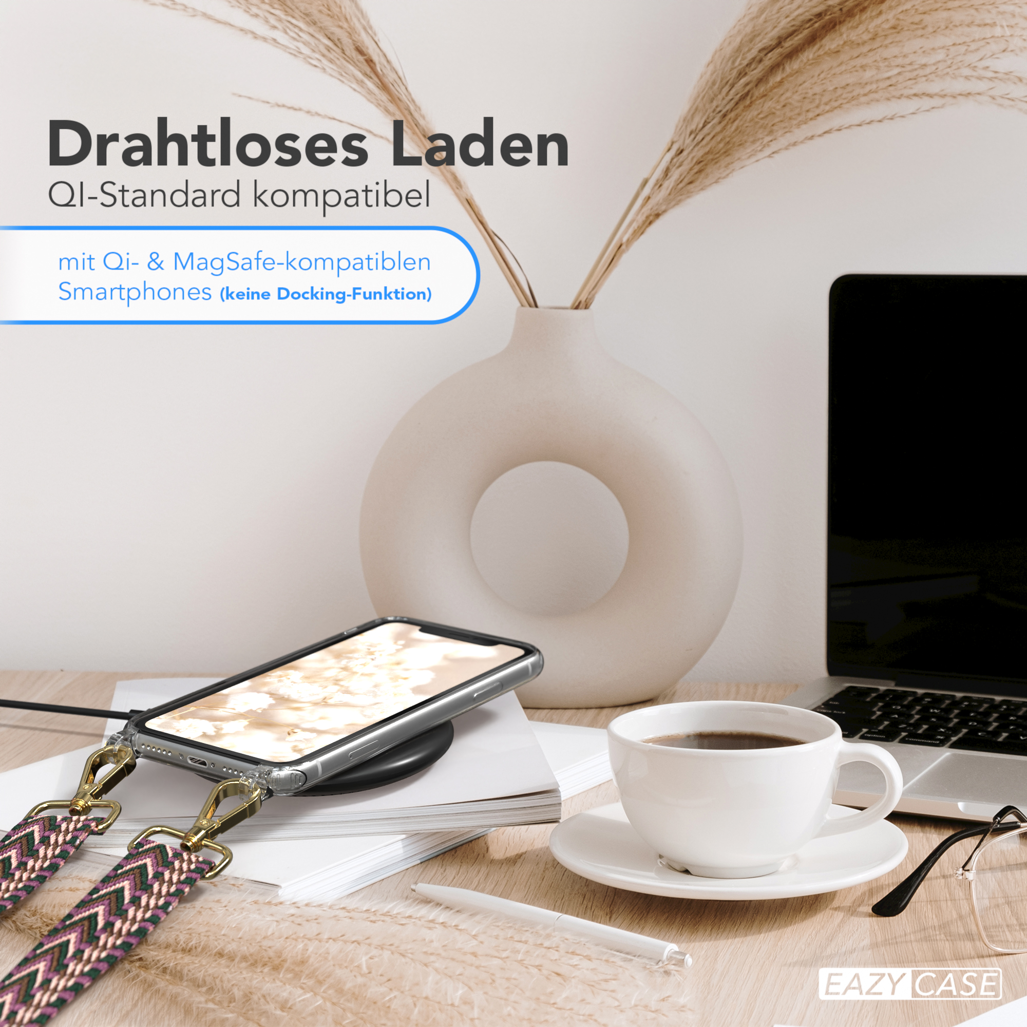 Ein Telefon wird kabellos auf einem Schreibtisch mit einer Kaffeetasse und Blumen geladen. Ein Stift liegt neben der Tasse.