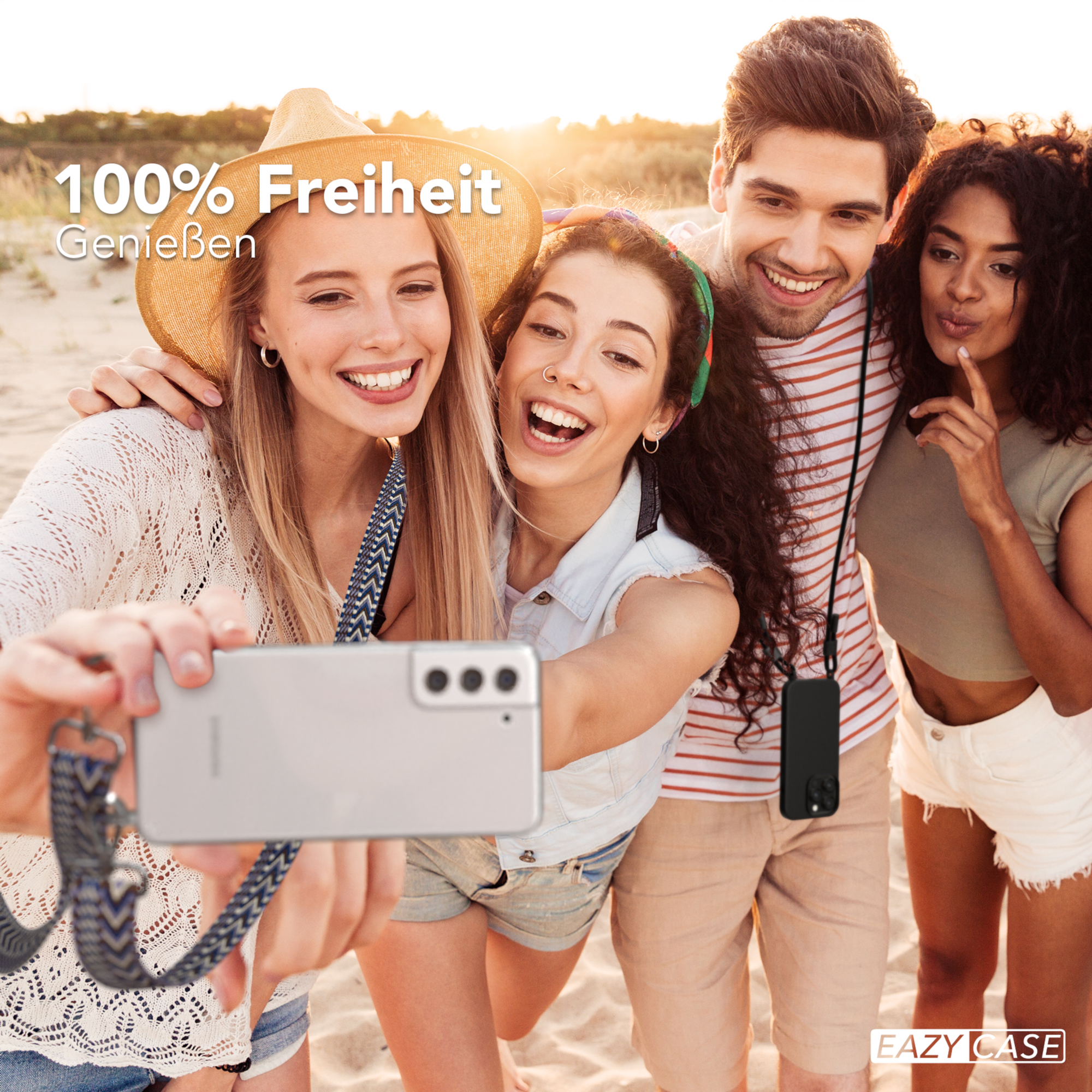 Vier Personen machen ein Selfie am Strand, das Telefon hat ein Schlüsselband um den Hals.