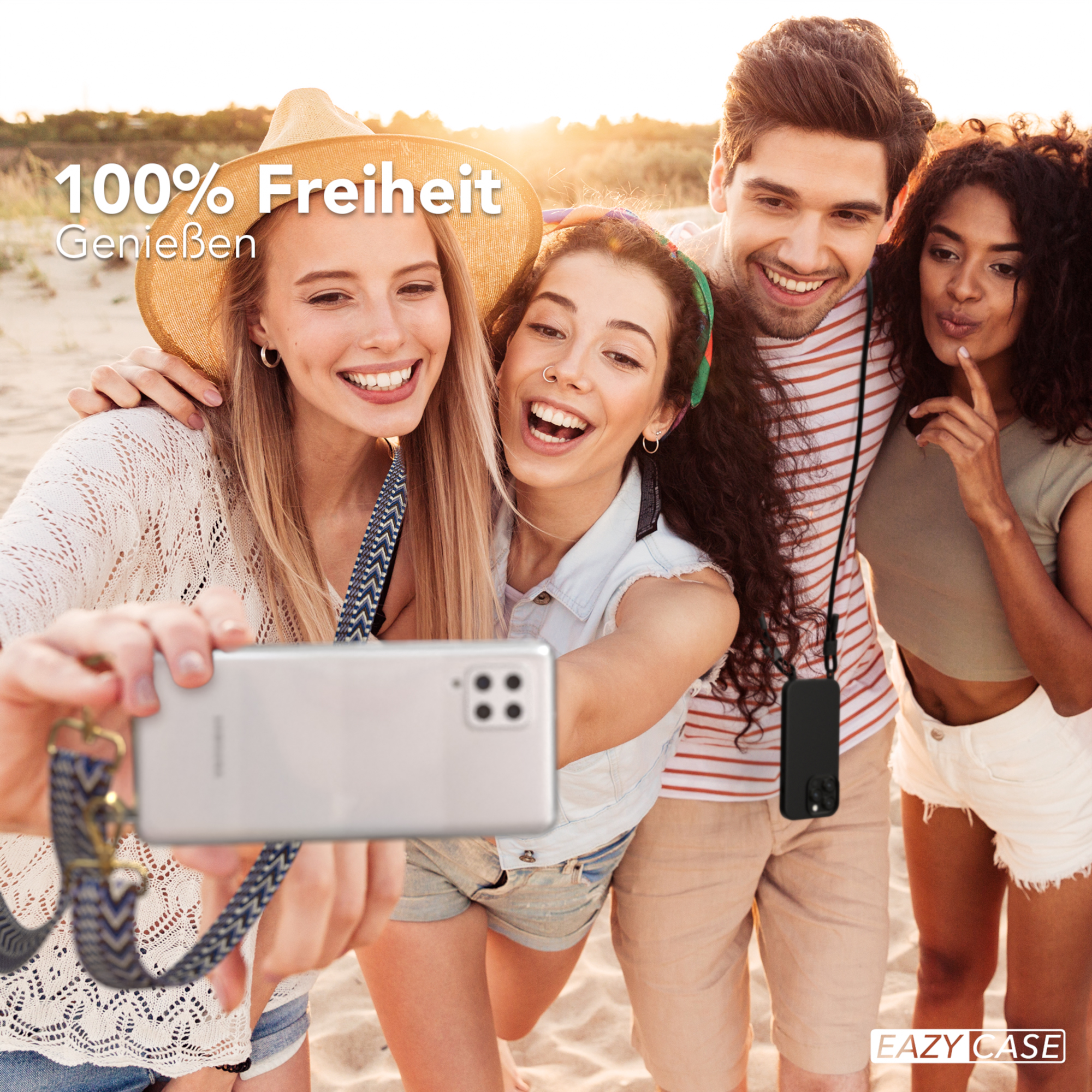 Vier Personen machen ein Selfie am Strand, das Telefon hat ein Schlüsselband um den Hals.