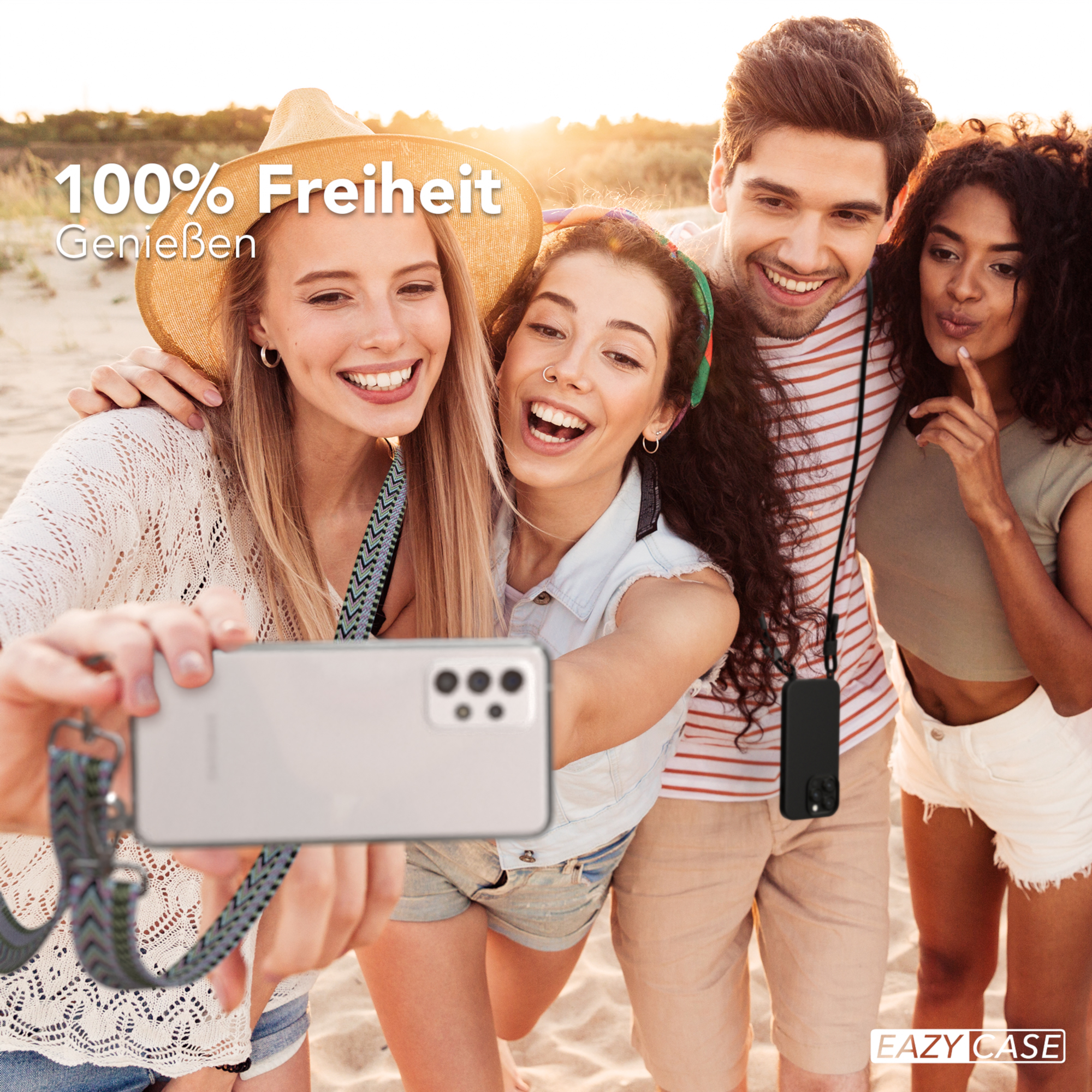 Vier Personen machen ein Selfie am Strand, eine Person hält ein Telefon mit Riemen.