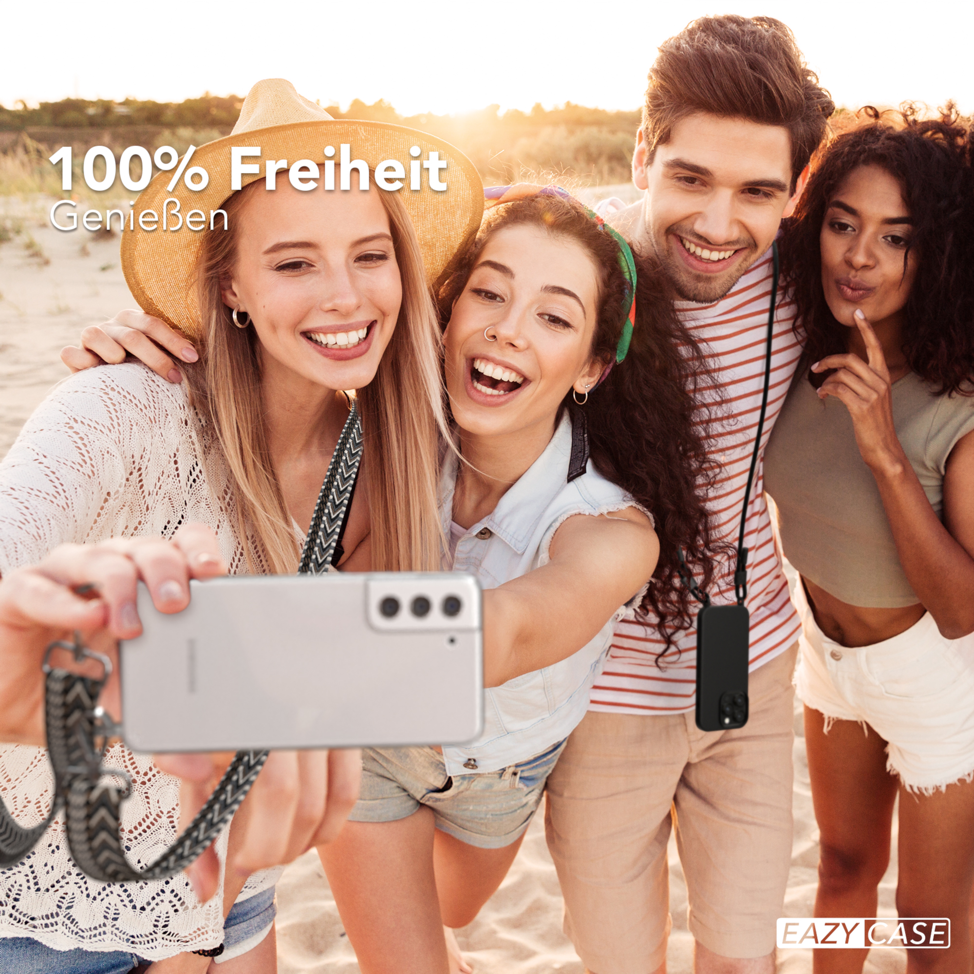 Vier Personen machen ein Selfie am Strand, halten ein Telefon mit Hülle.