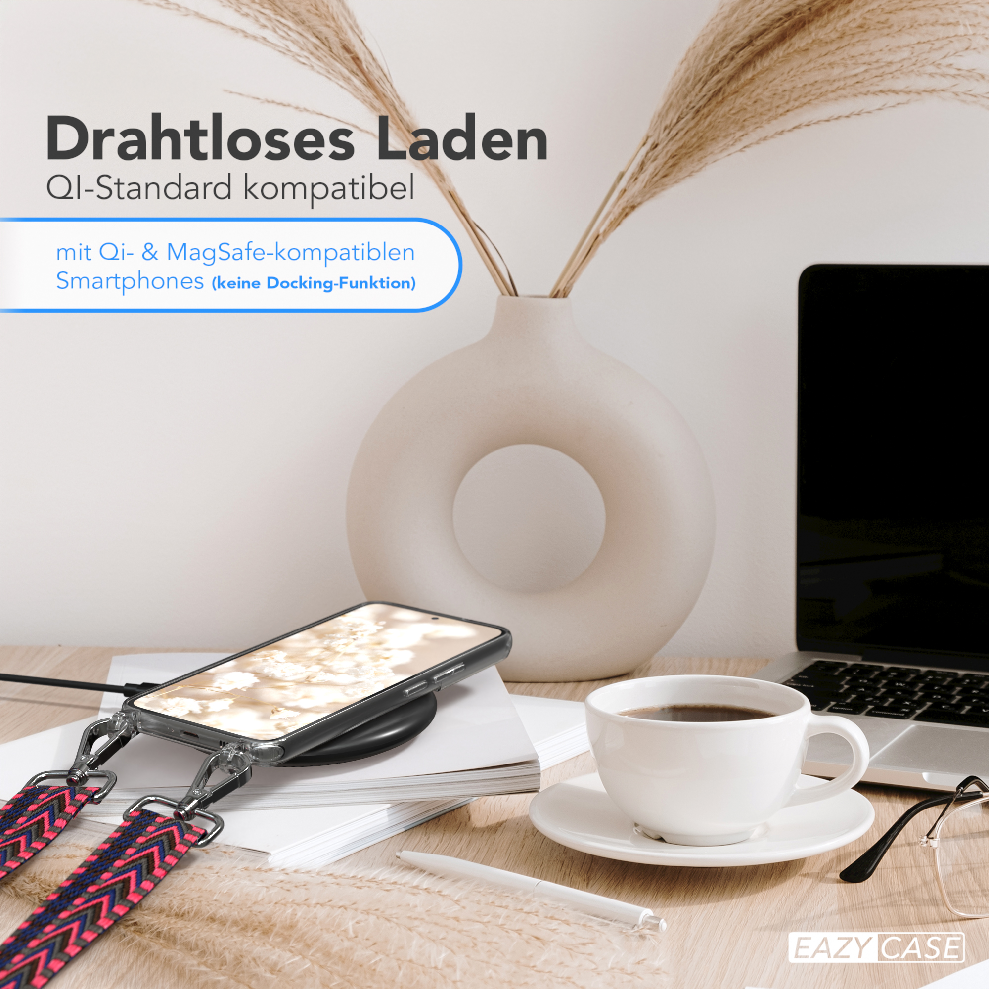 Telefon lädt kabellos auf. Kaffeetasse, Laptop und Dekorationen im Hintergrund.