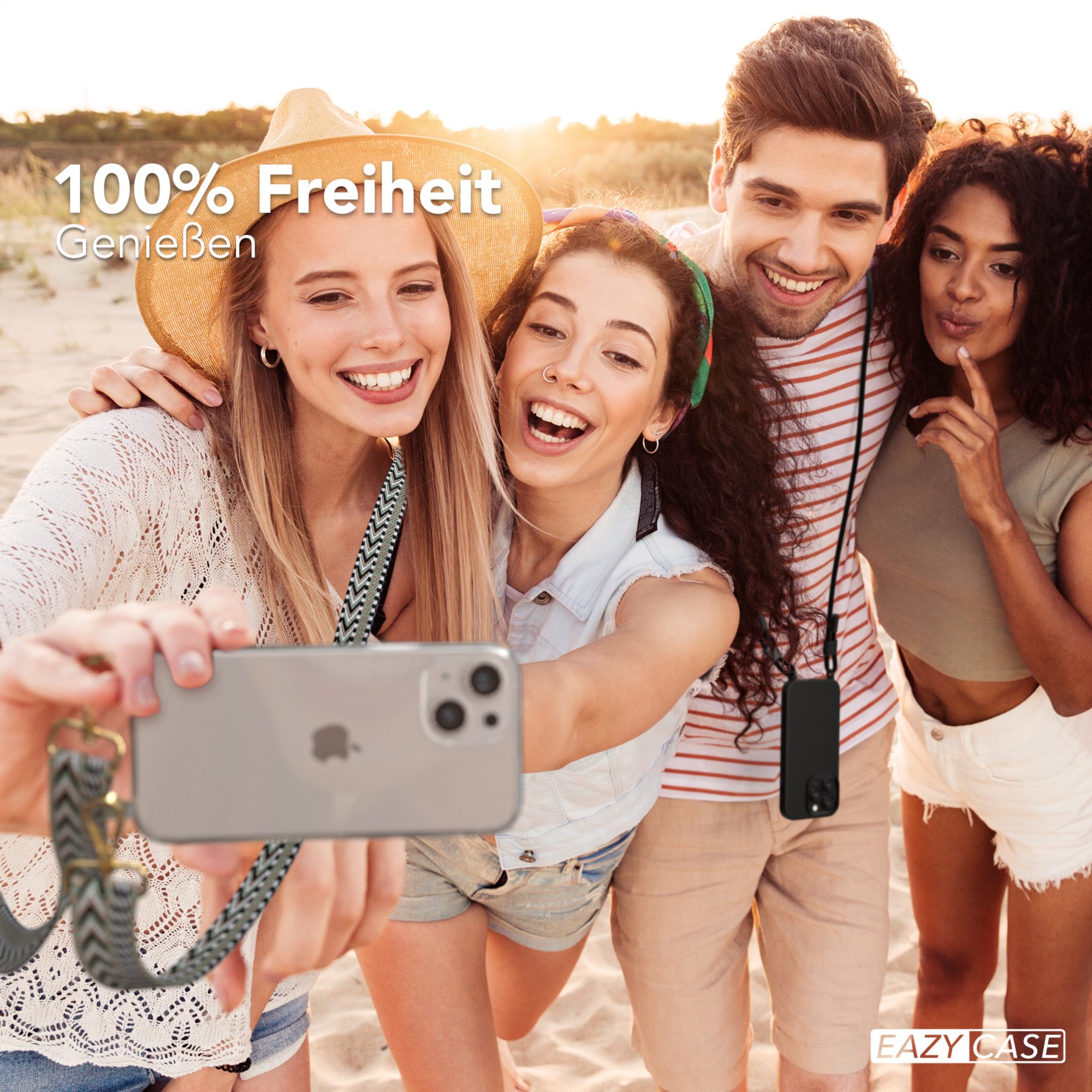 Vier Personen machen ein Selfie mit einem Telefon, zwei halten das Telefon und lächeln.
