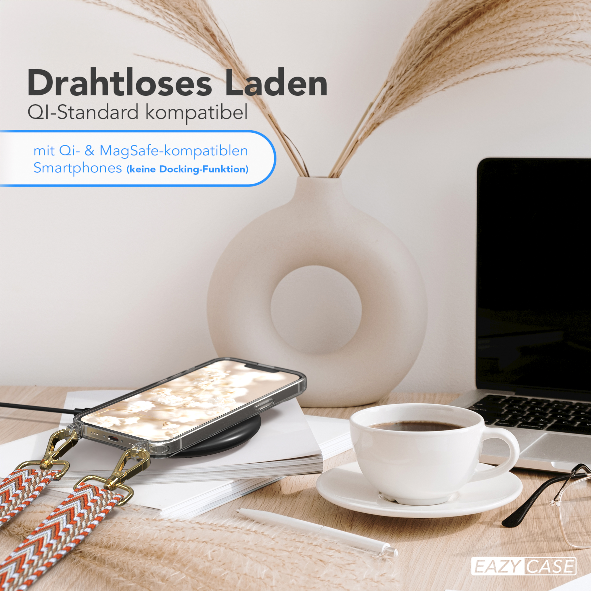 Ein Telefon auf einem kabellosen Ladegerät, mit einer Kaffeetasse, Brille und einer Vase mit Pampasgras.