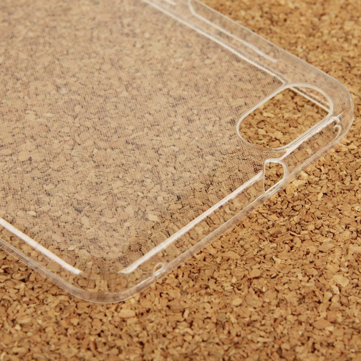 Eine transparente Handyhülle auf einer Korkoberfläche, zeigt Umriss und Textur.