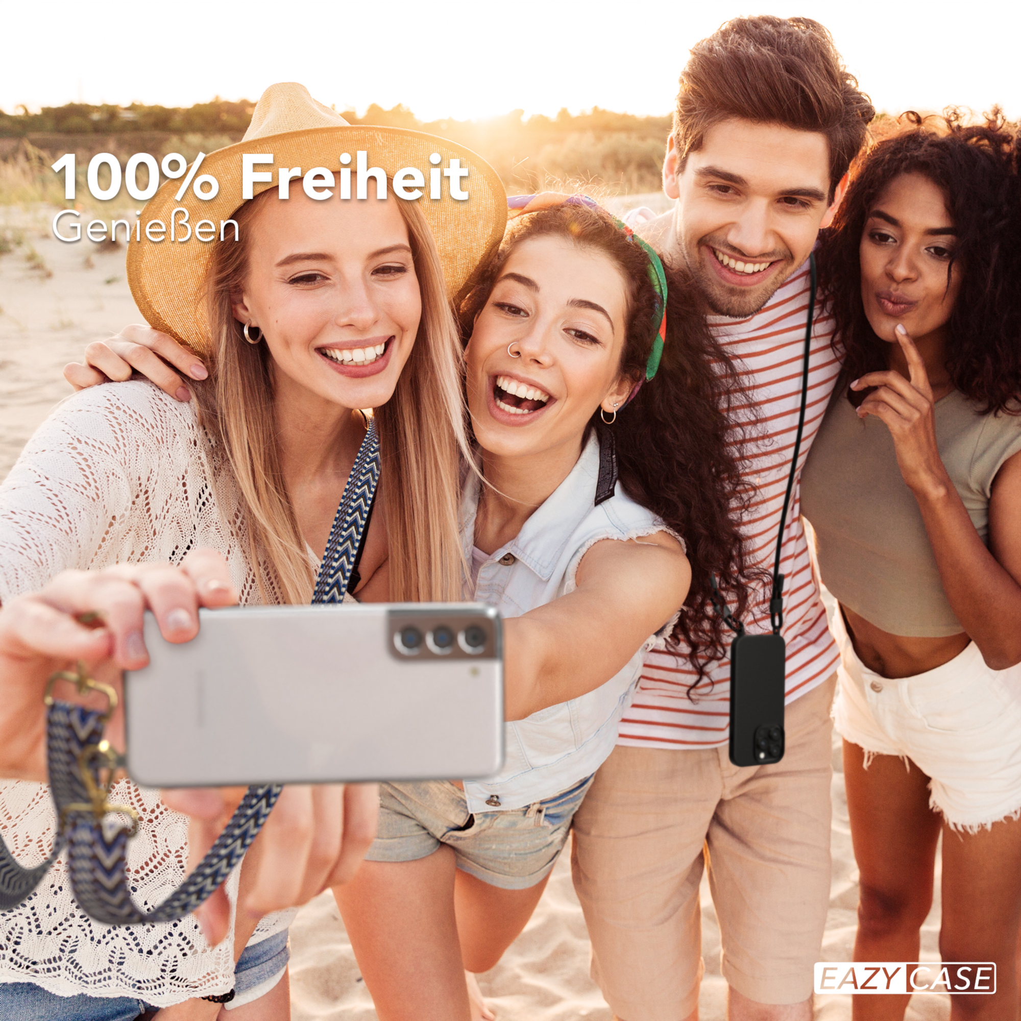 Vier Personen machen ein Selfie am Strand. Einer hält das Telefon mit einem Band. Alle lächeln.