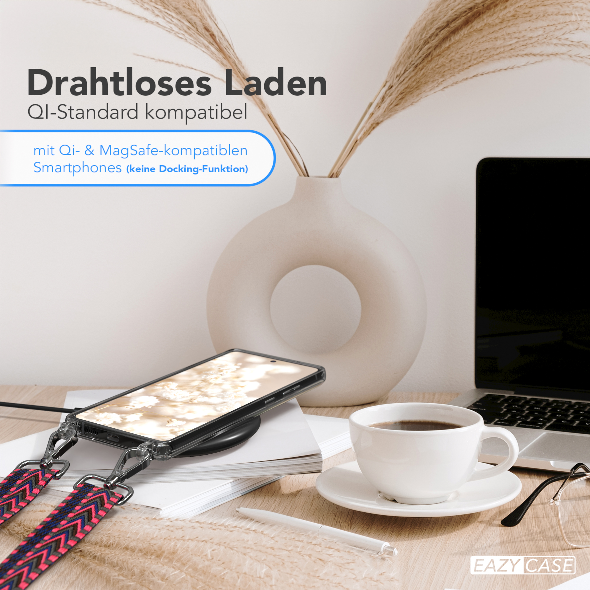 Telefon lädt kabellos. Kaffeetasse, Brille und Blumenvase stehen auf dem Tisch.