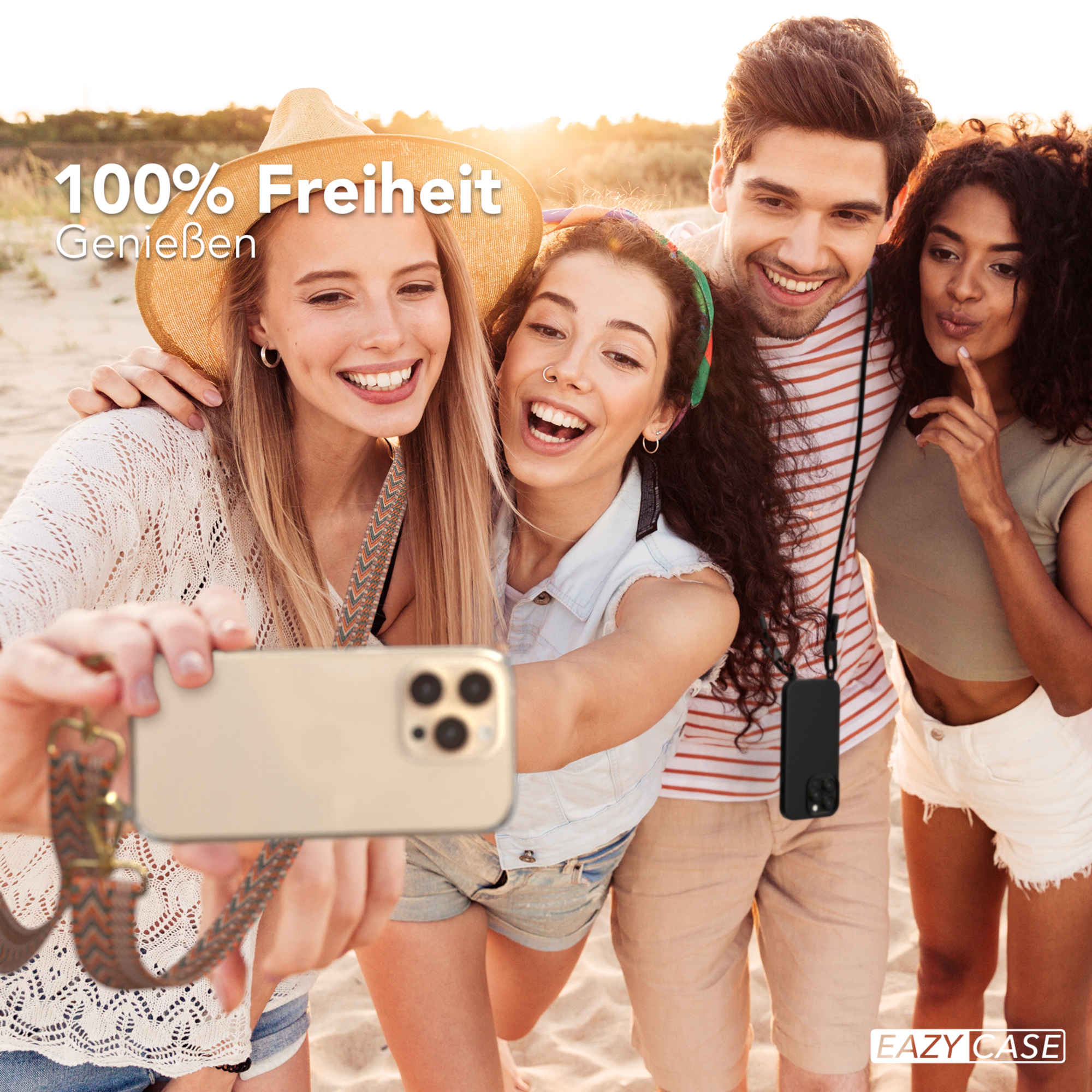 Vier junge Leute machen ein Selfie am Strand. Das Telefon hat ein Lanyard, und der Text lautet "100% Freiheit".