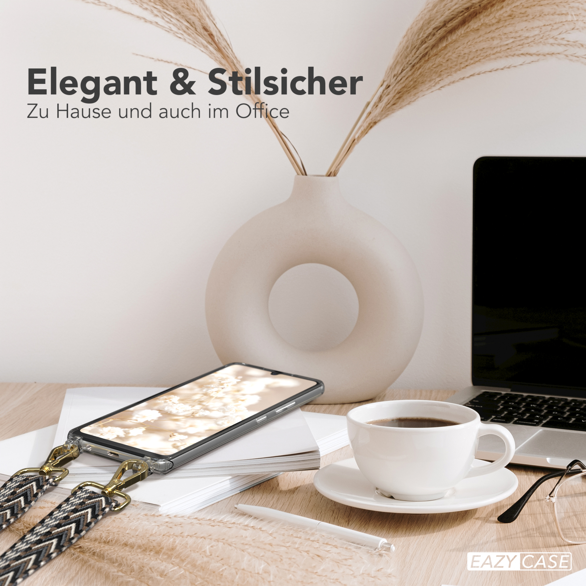 Ein Telefon mit einem Gurt und einer durchsichtigen Hülle auf einem Schreibtisch mit Laptop und Kaffee.