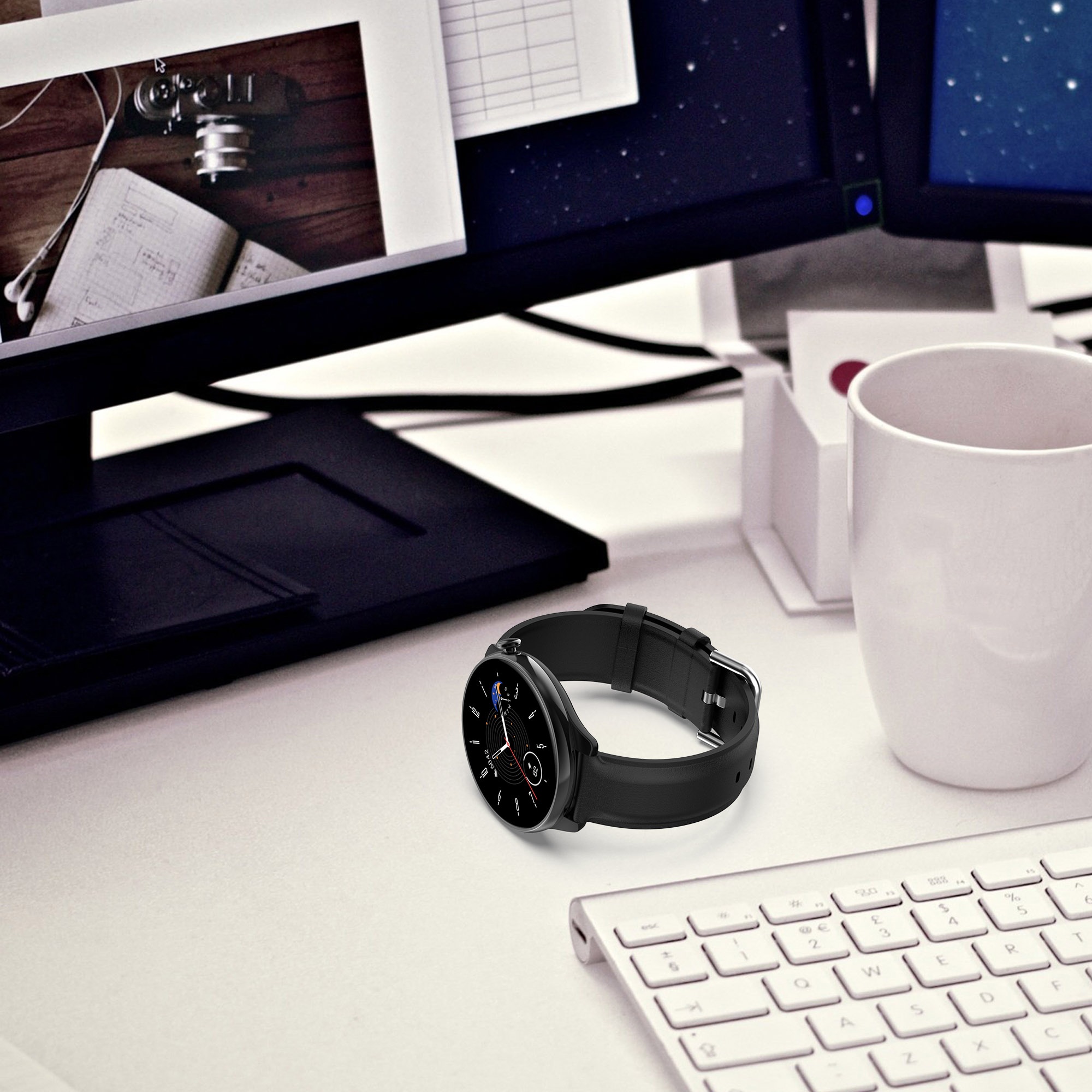 Smartwatch auf einem Schreibtisch mit Tastatur, Monitor und Zubehör. Schwarze Uhr mit schwarzem Armband.
