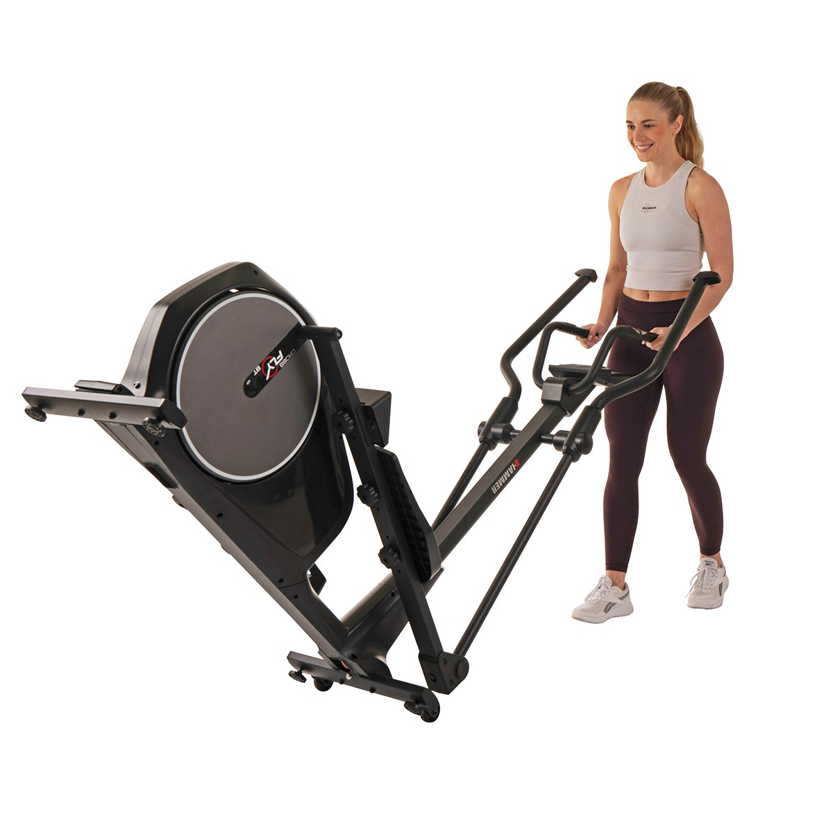 Frau benutzt schwarzen Crosstrainer, in einem weißen Raum.