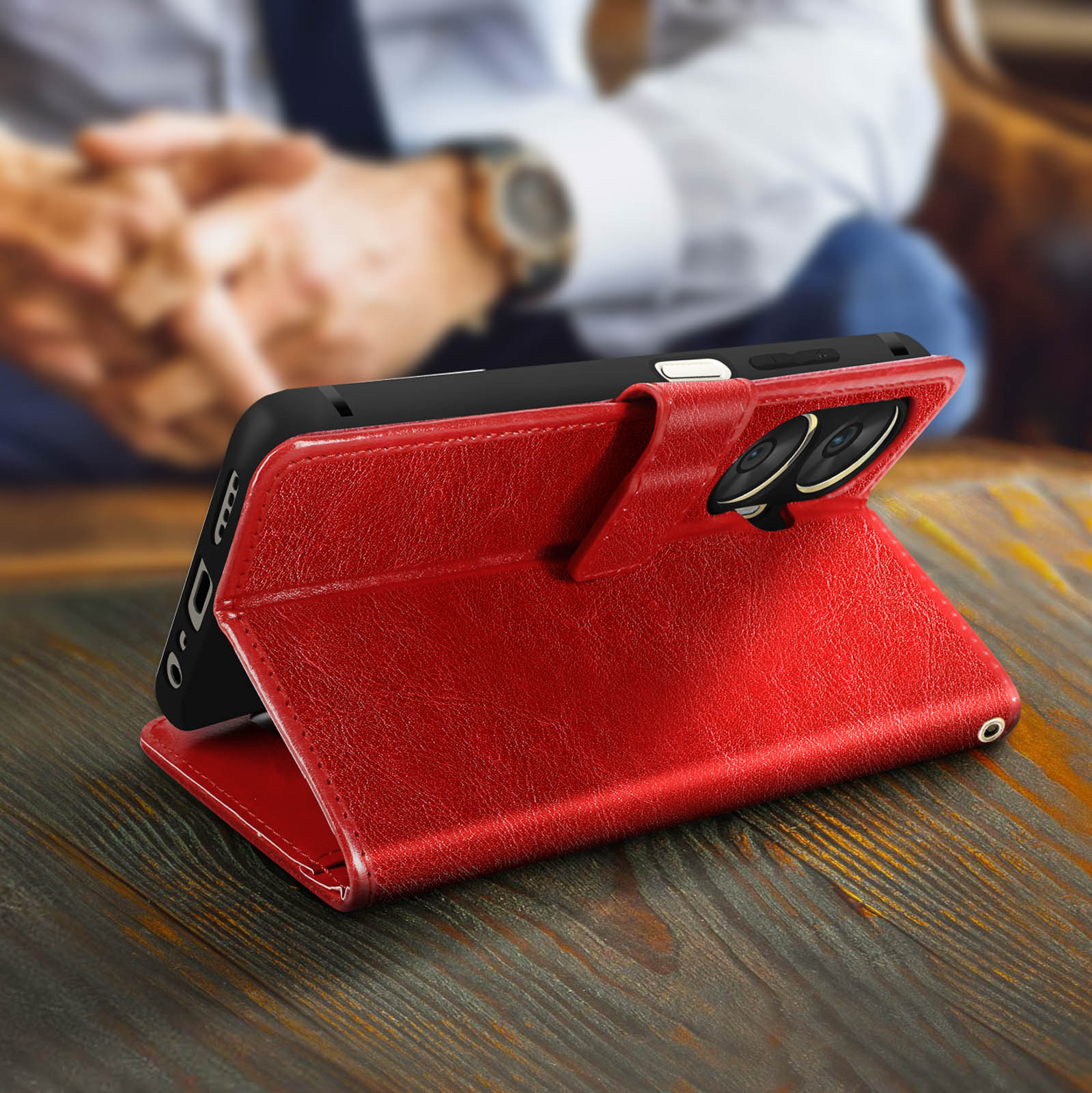 Eine rote Leder-Handyhülle ist geöffnet und zeigt das Telefon auf einem Holztisch.