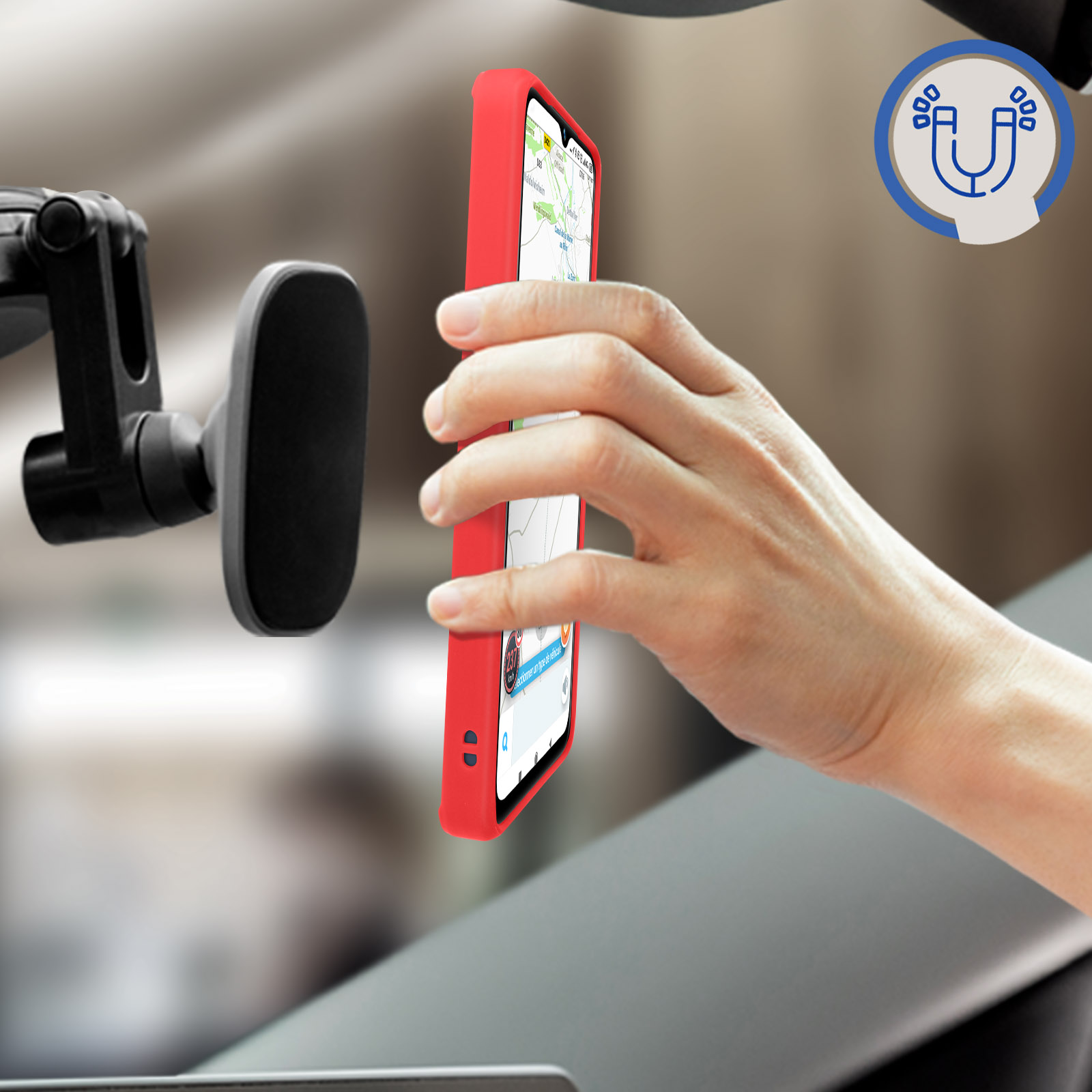 Una mano che tiene un telefono rosso accanto a un supporto per auto su un parabrezza. Il telefono mostra una mappa.