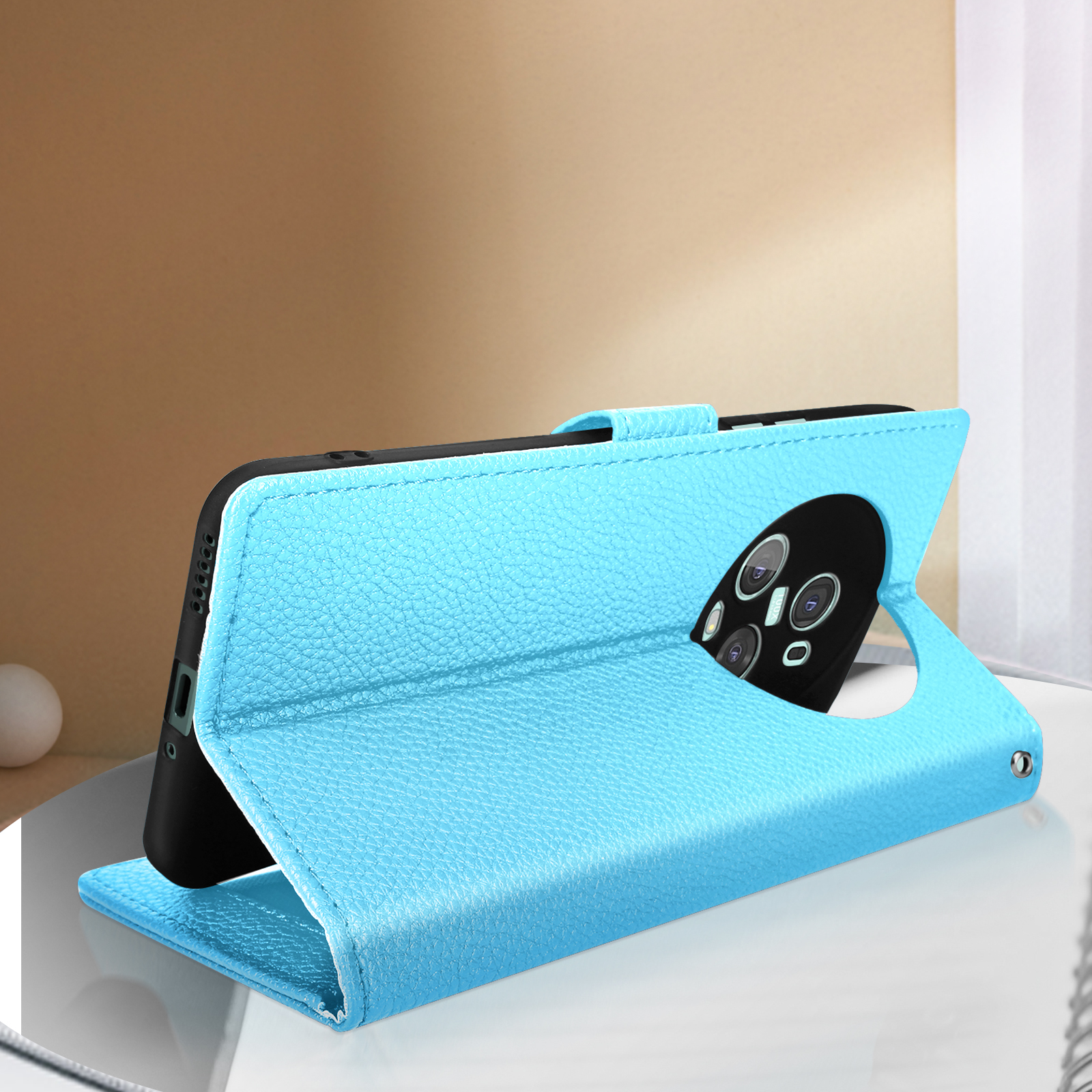 Eine blaue Handyhülle mit einem Telefon darin, offen und in Ständerposition.