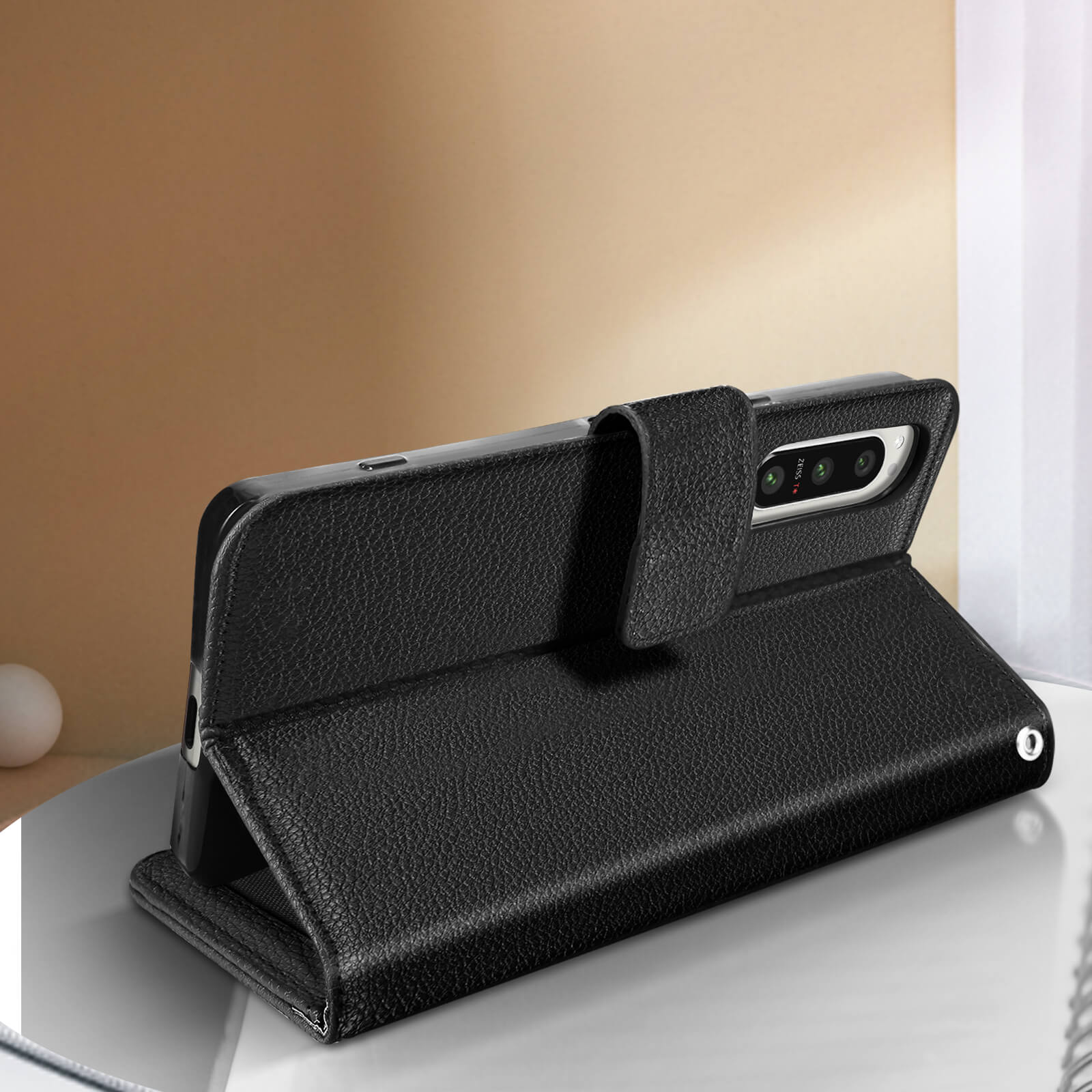 Funda de teléfono de cuero negro, abierta de pie.