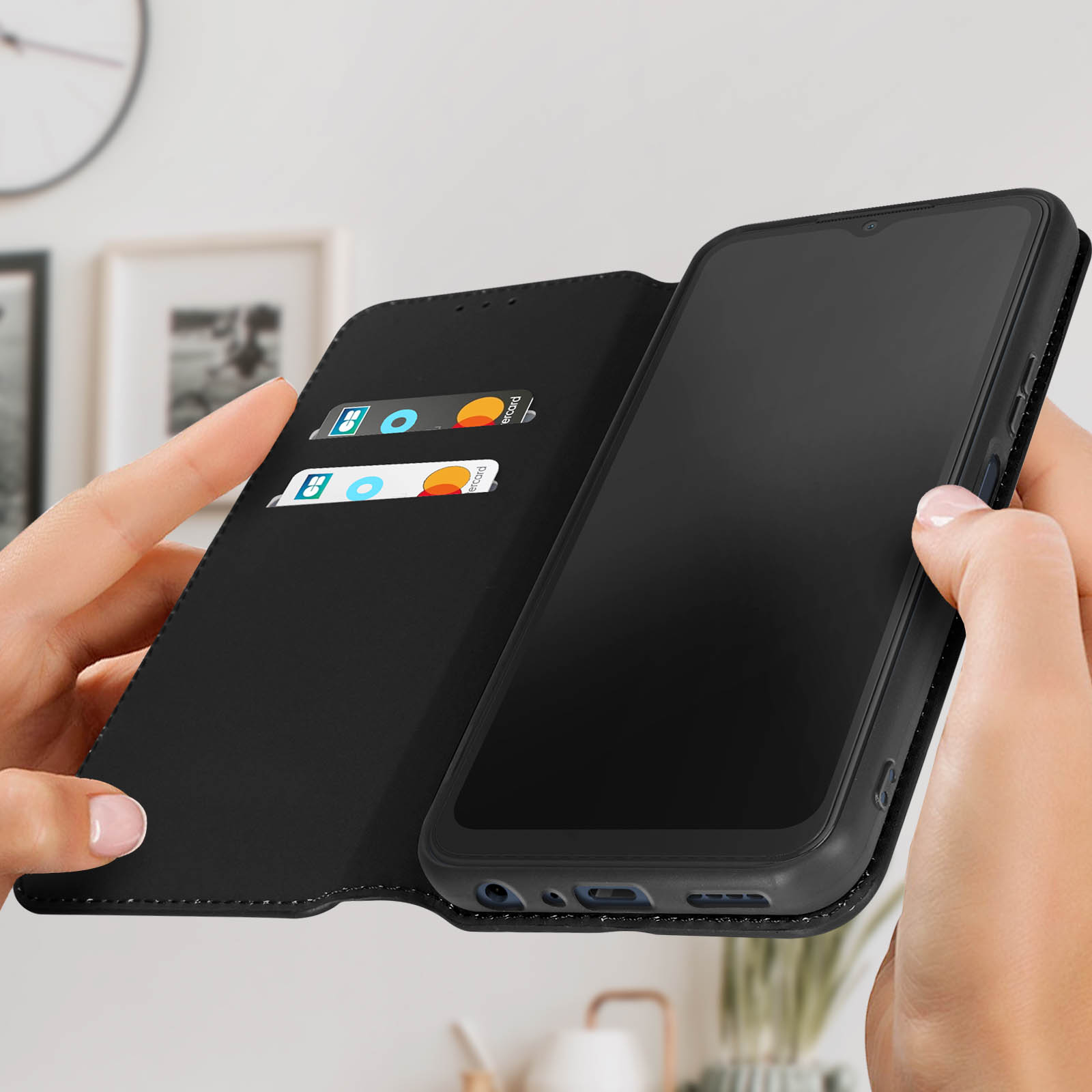 Schwarze Handyhülle, offen, mit Karten und Telefon, gehalten von zwei Händen.