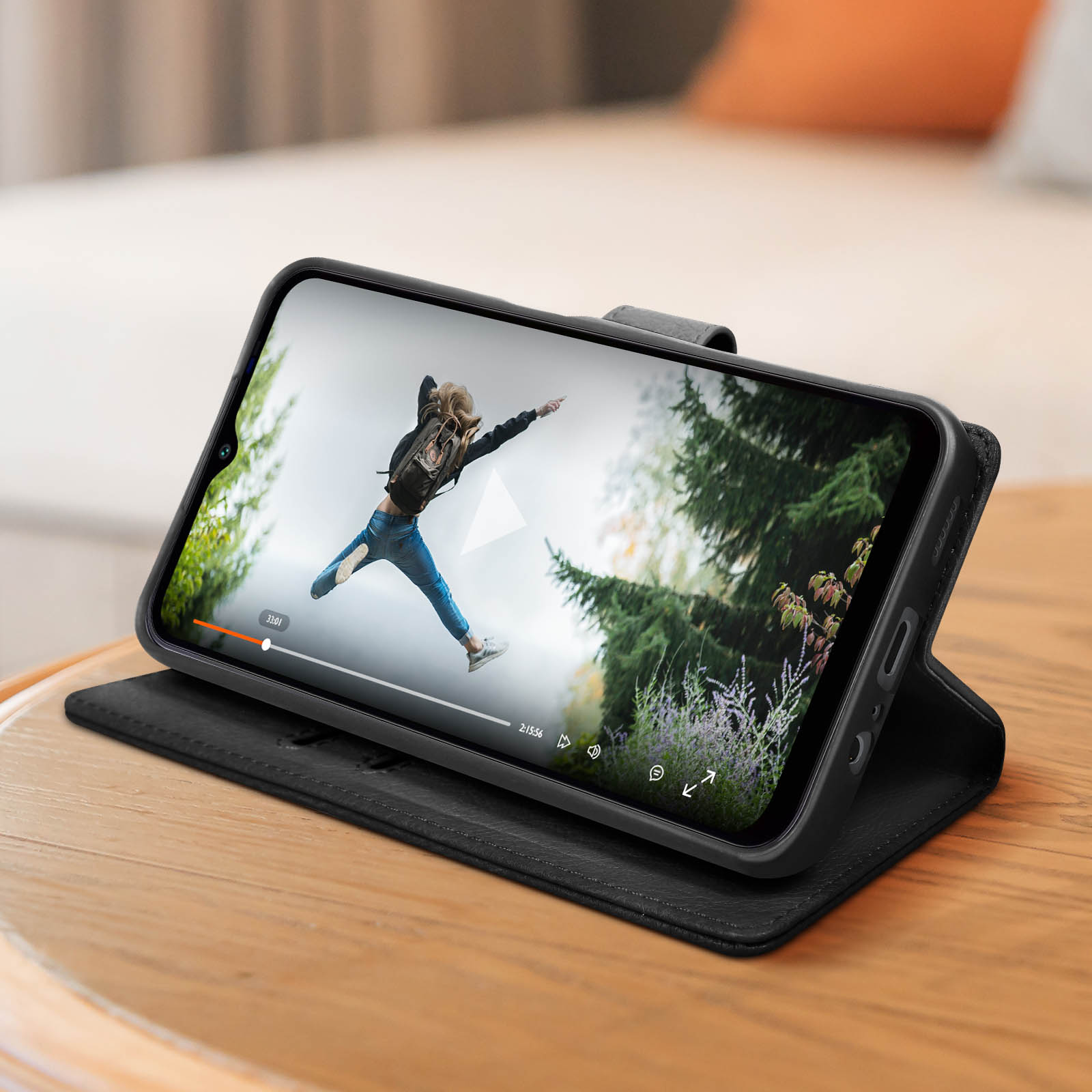 Telefoon met video, open op een houten tafel. Vrouw die springt in een park.