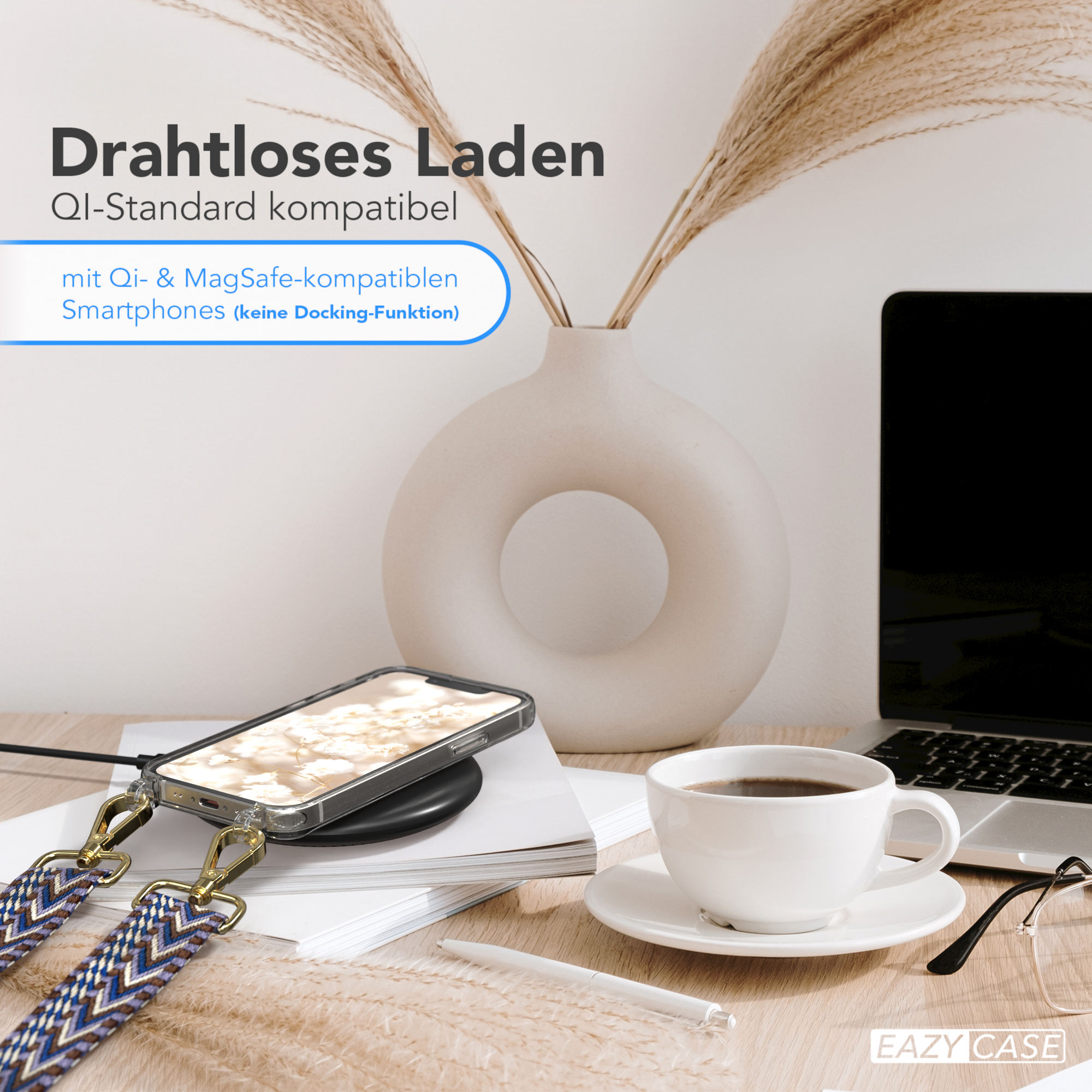 Telefon auf kabellosem Ladegerät. Tasse Kaffee, Laptop und Vase mit Pflanzen auf einem Holztisch.