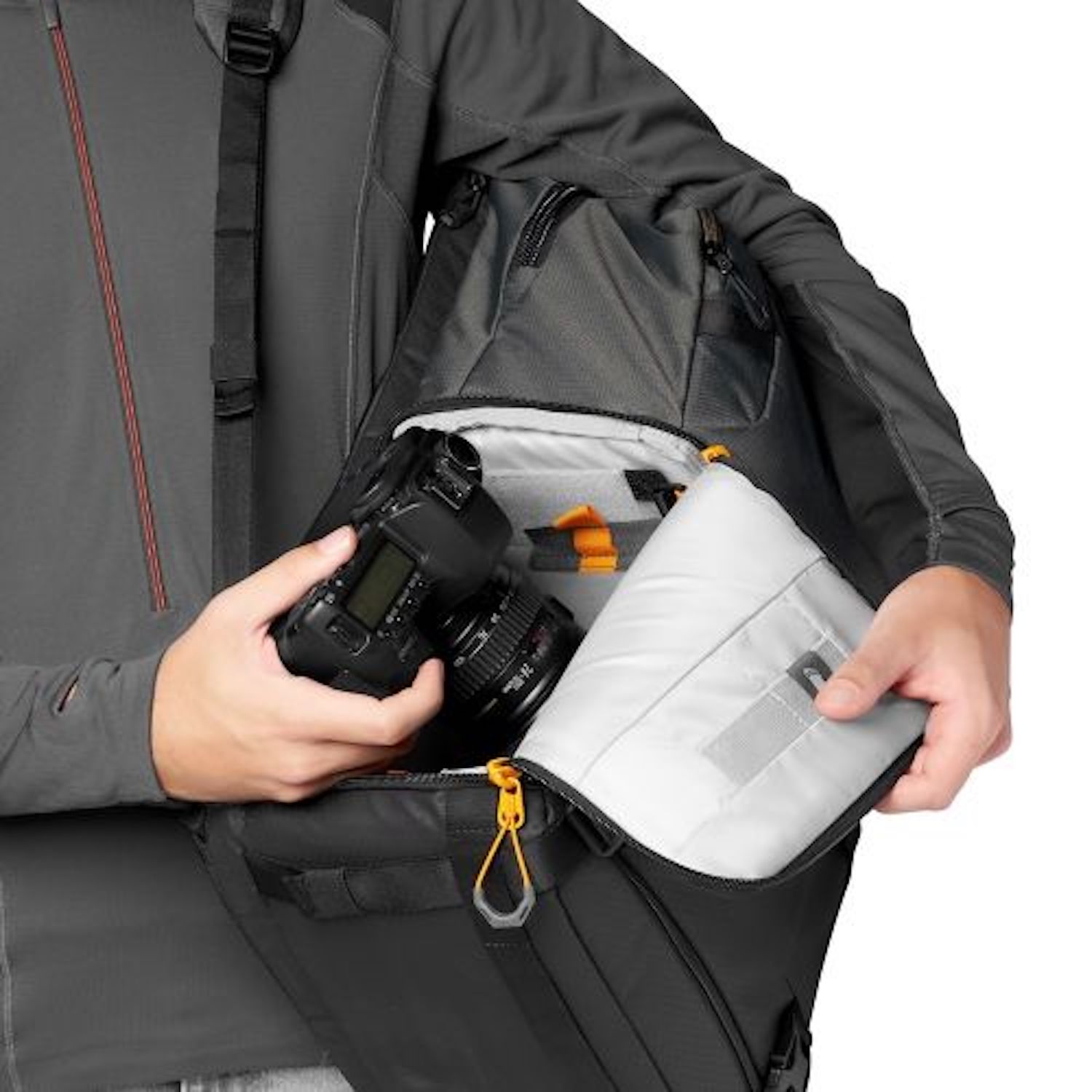 Personne tenant un appareil photo dans un sac. Le sac est ouvert, montrant du matériel photo.