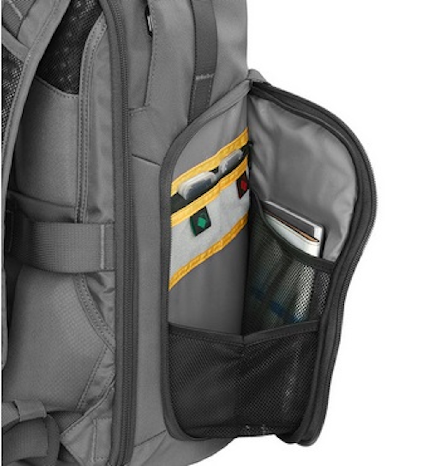 Primer plano de un bolsillo de mochila que contiene un cuaderno, bolígrafos y otros objetos pequeños.