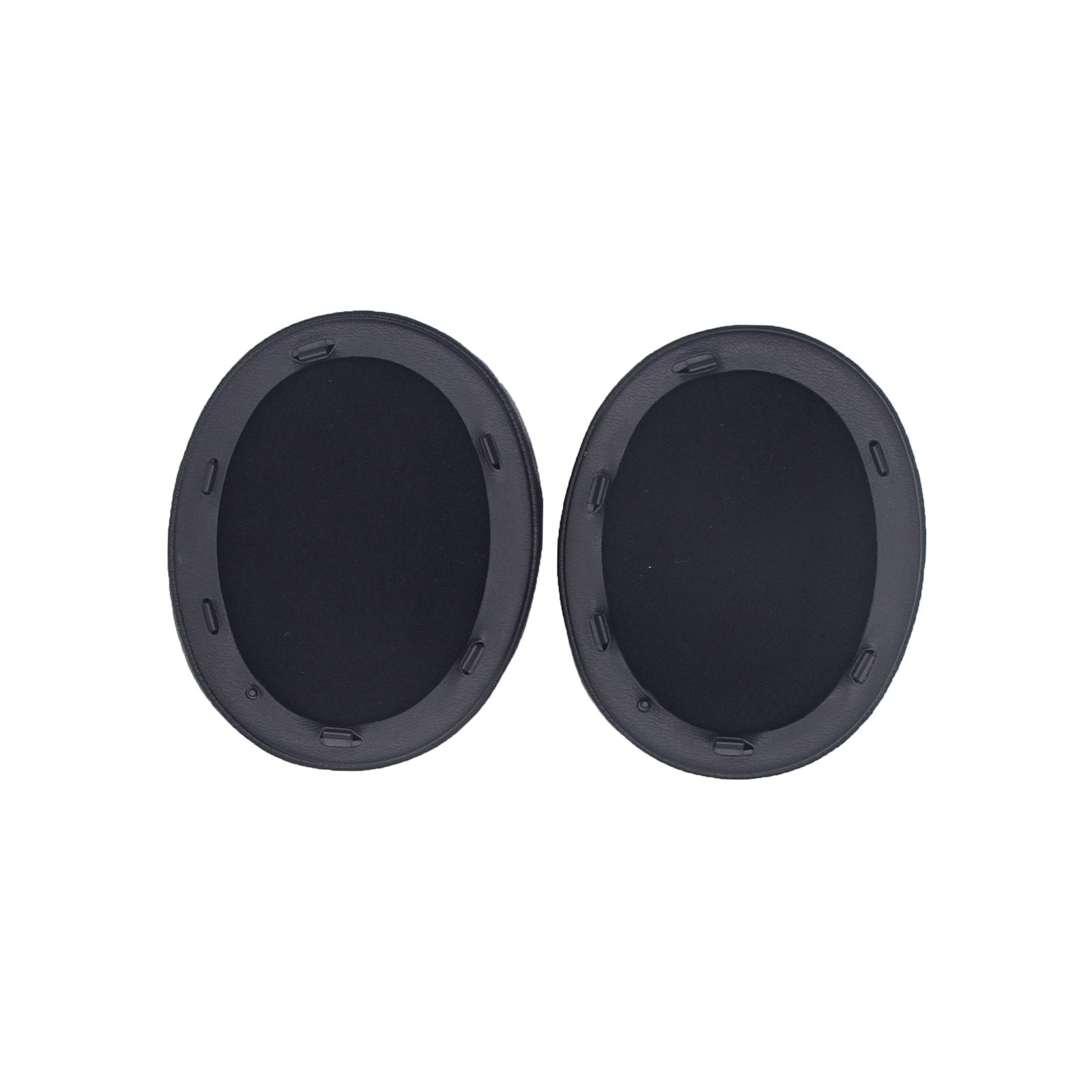 Dwie czarne, owalne wkładki do uszu obok siebie, z ciemną, teksturowaną powierzchnią, gotowe do użycia.