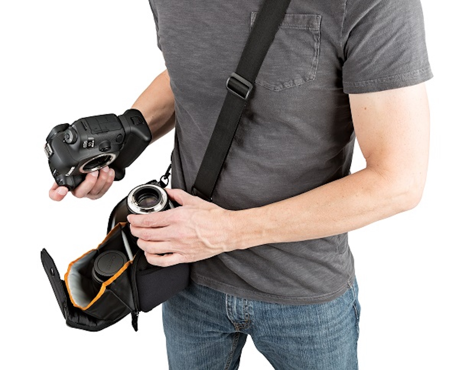 Mężczyzna trzymający aparat, z drugim obiektywem w torbie. Białe tło.