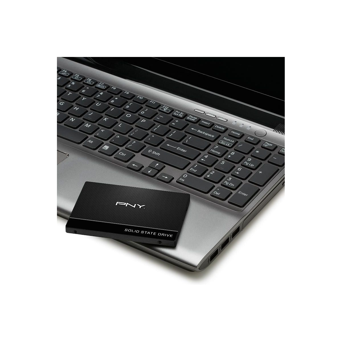 SSD auf einer Laptop-Tastatur. Die SSD ist schwarz, der Laptop grau.