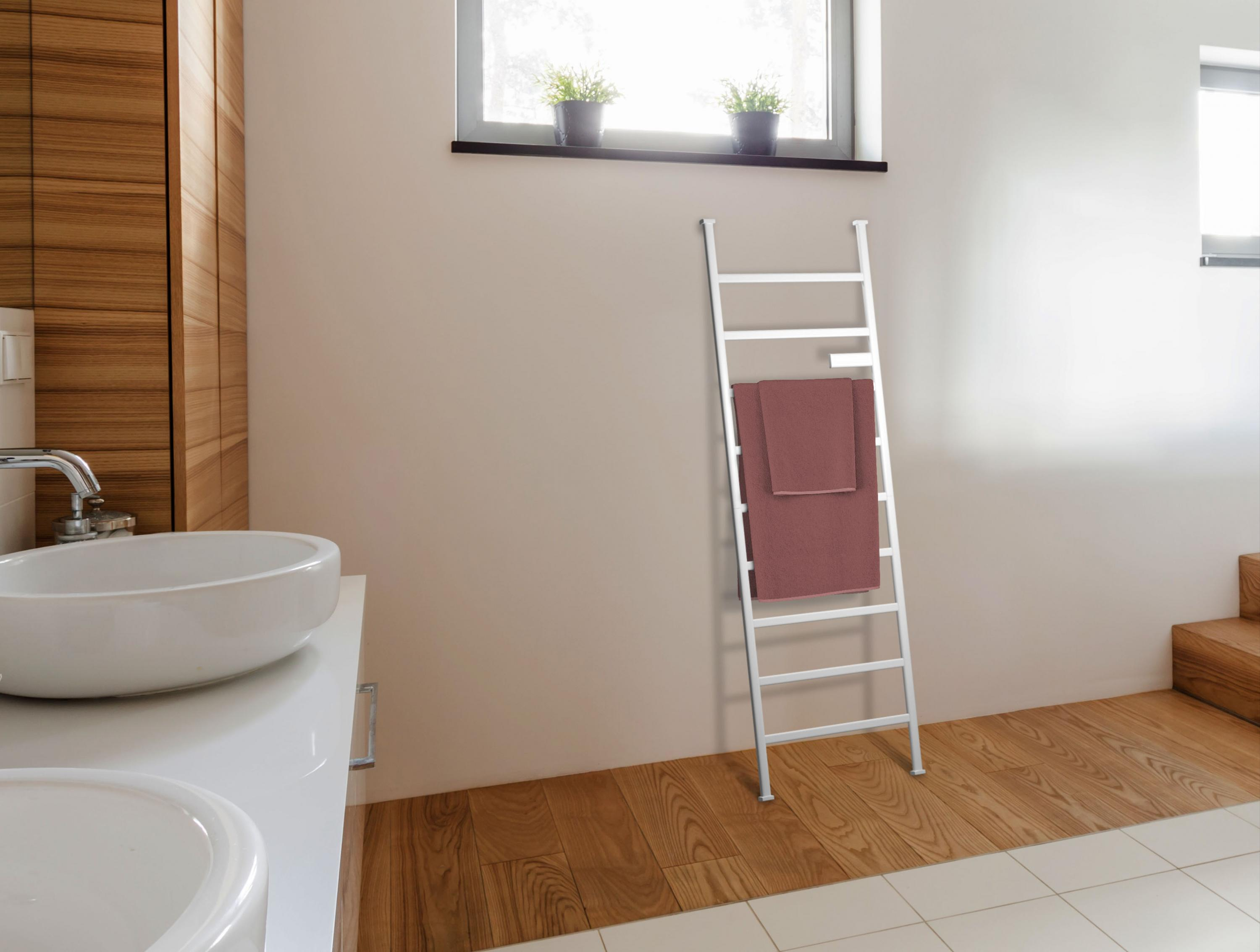 Un toallero blanco tipo escalera en un baño. Un lavabo es visible en el lado izquierdo de la habitación.