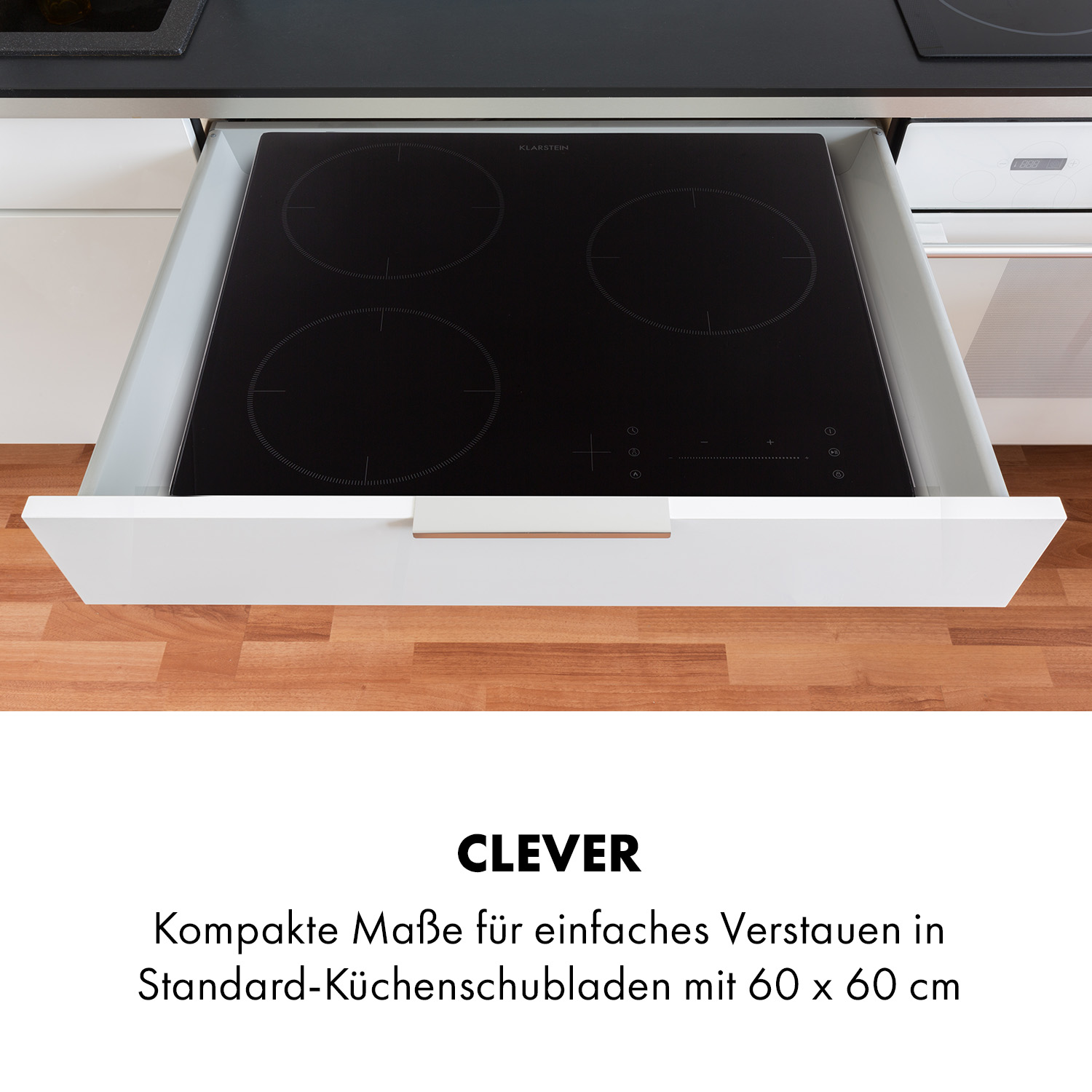 Cajón de cocina blanco abierto con encimera negra. El cajón tiene un tirador de cobre. Fondo blanco.