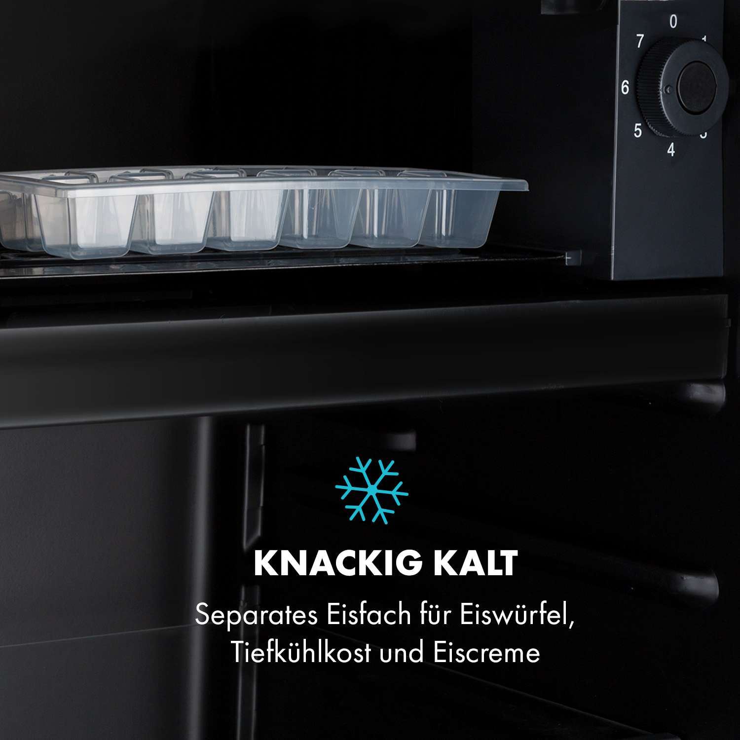 Ein offener schwarzer Kühlschrank mit Eiswürfelschale. Der Text sagt 'KNACKIG KALT'.