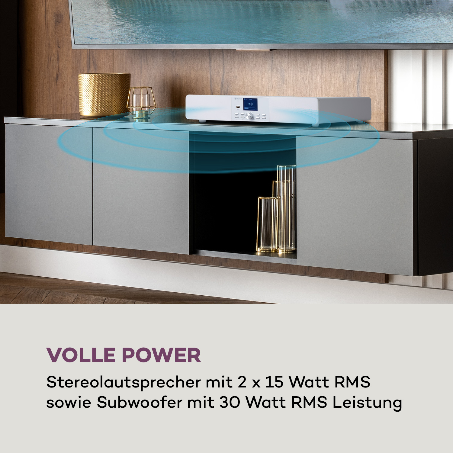 Eine weiße Soundbar auf einem Schrank mit einem Fernseher darüber und einer dekorativen Vase.