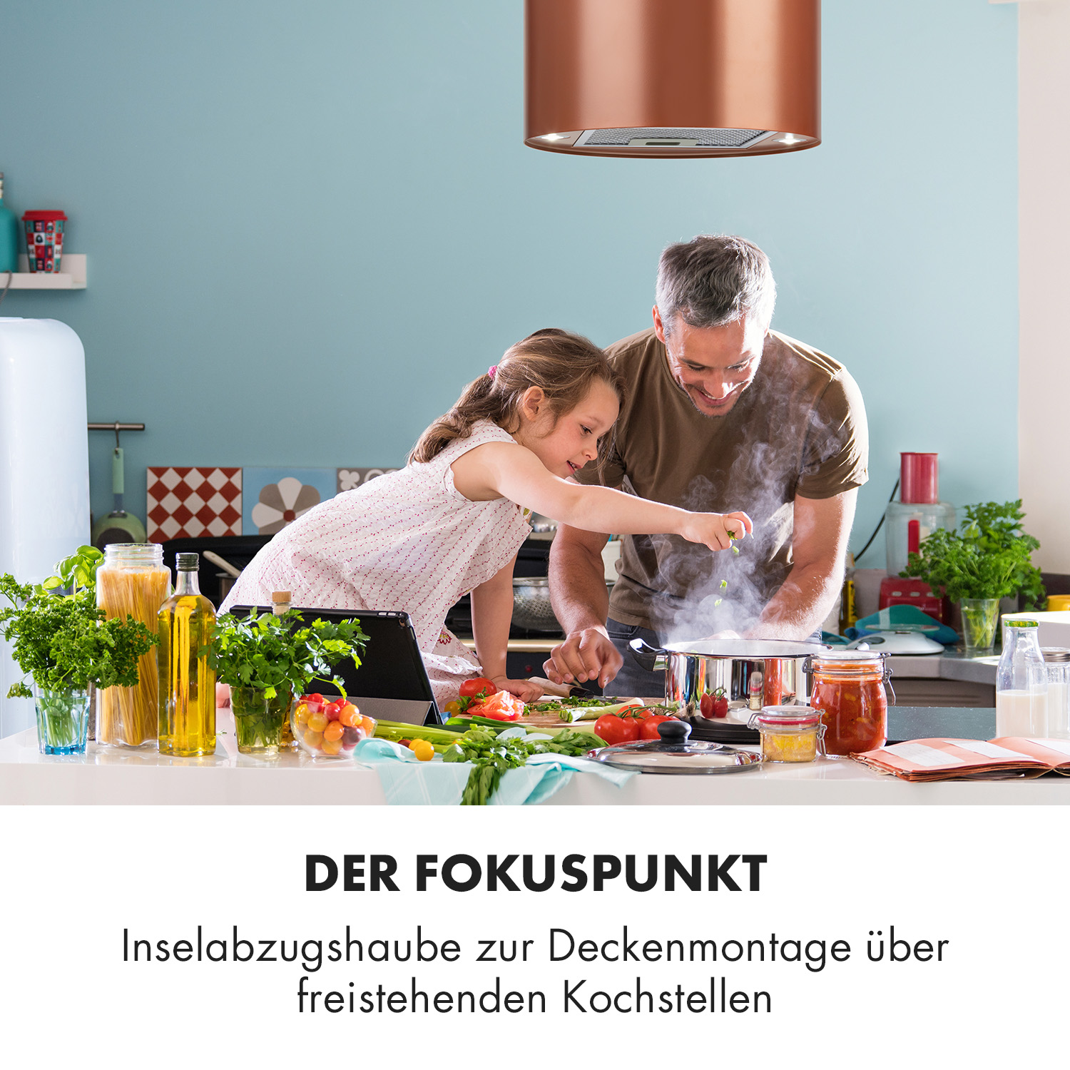 Vater und Tochter kochen in einer Küche mit Kupfer-Dunstabzugshaube über dem Herd.
